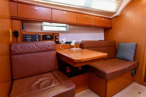 Interior of 2016 Bavaria Cruiser 41 yacht with wooden cabinetry and leather seating.