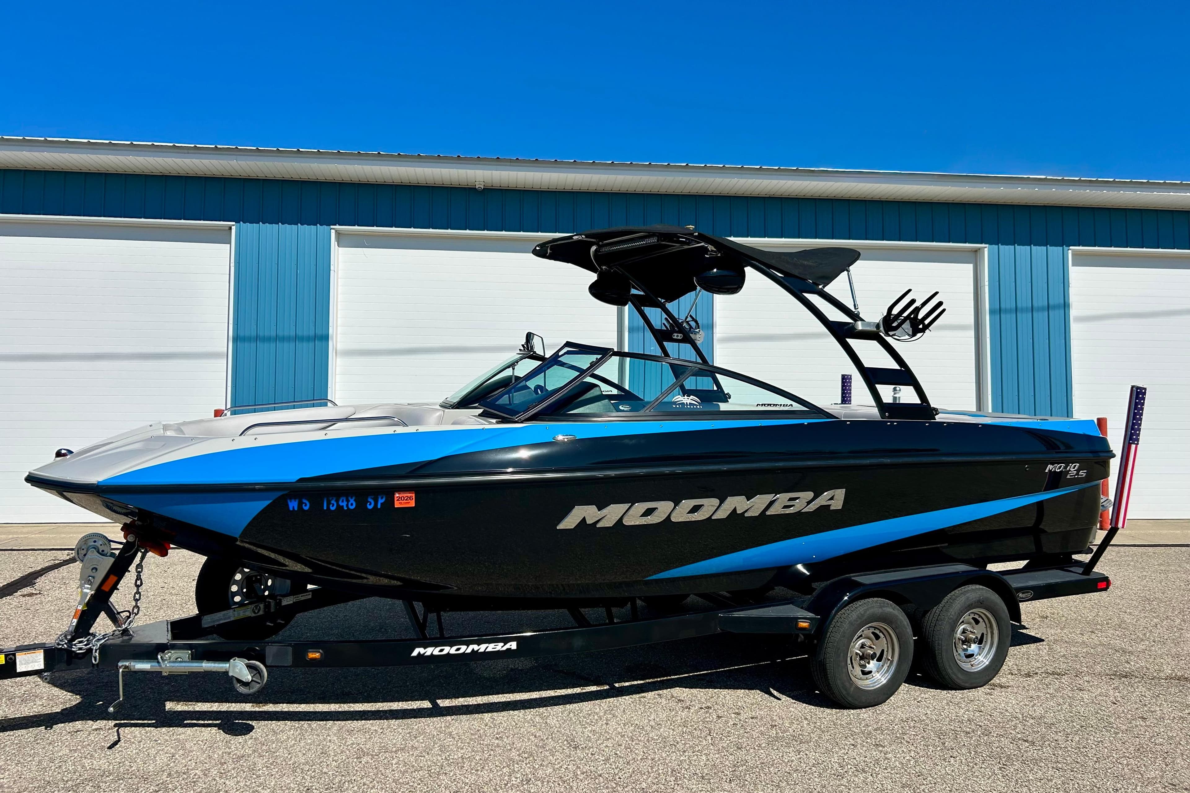 2012 Moomba Mojo 2.5 boat with blue and black design, parked on a trailer.