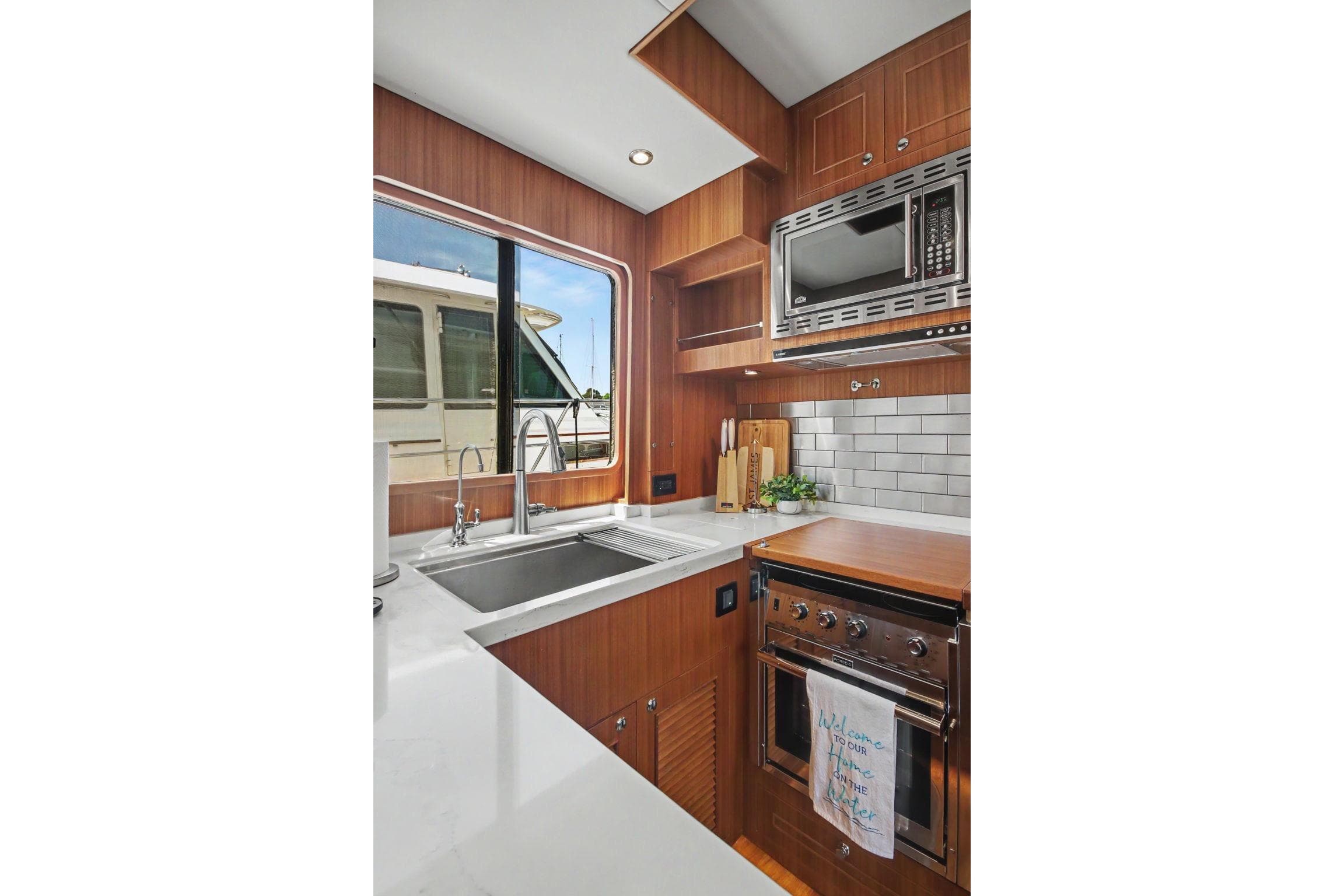 Modern kitchen in 2022 North Pacific 45 Pilothouse yacht with sleek appliances and wood finish.