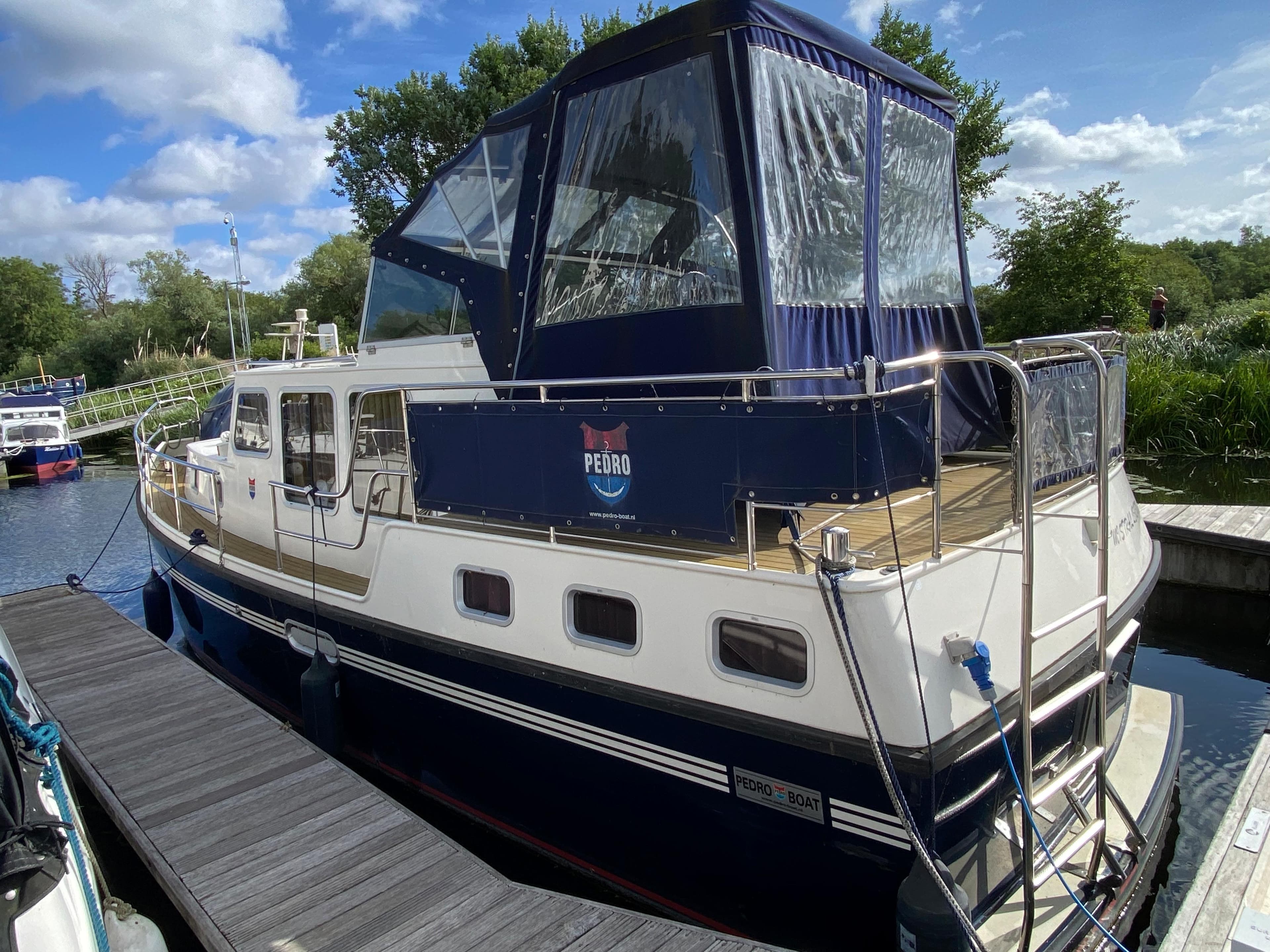 2007 Pedro Marin 30 boat docked, featuring a blue canopy and white hull.