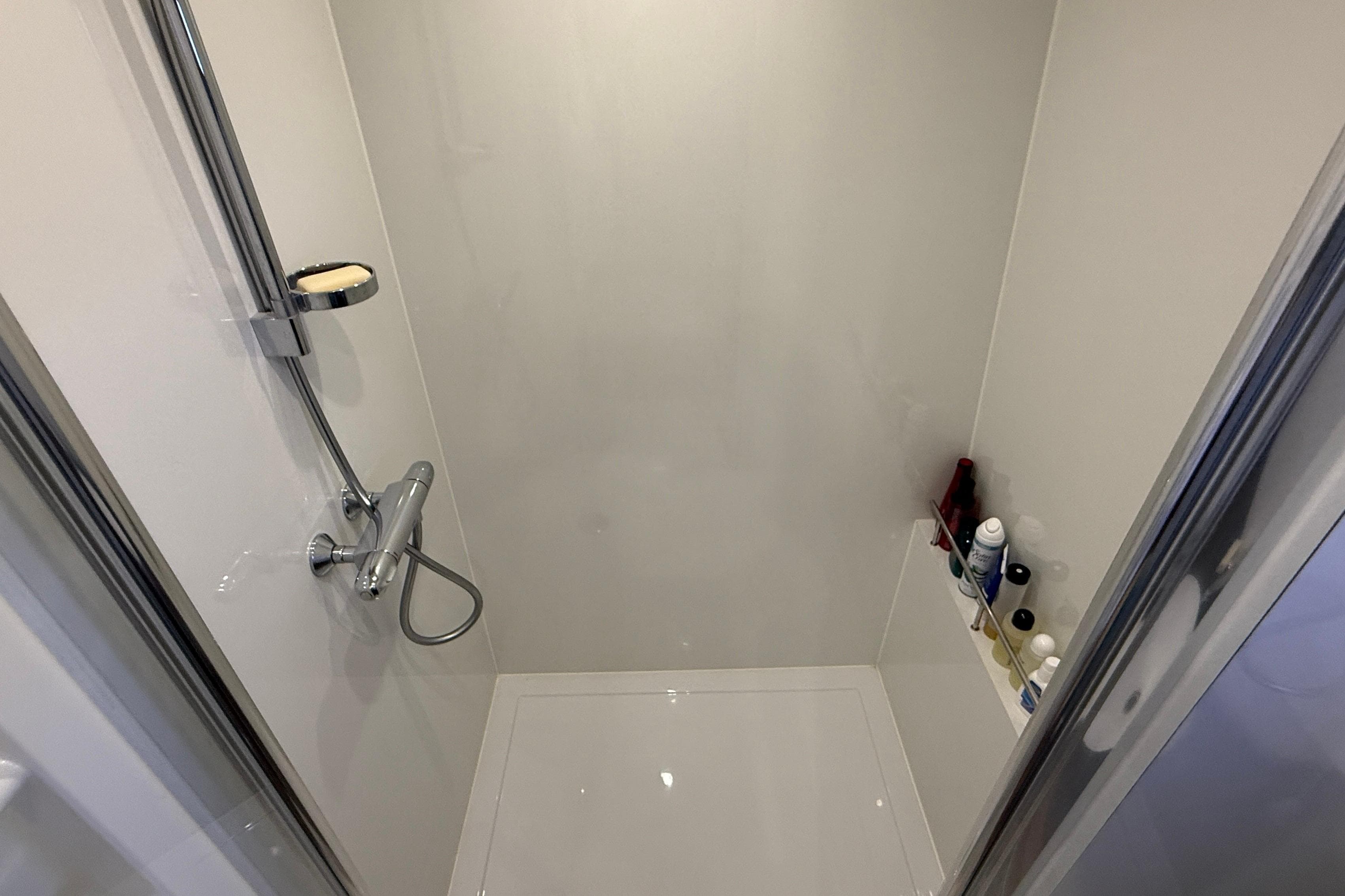 Modern shower area in 2021 Elling E6 yacht, featuring chrome fixtures and toiletries.