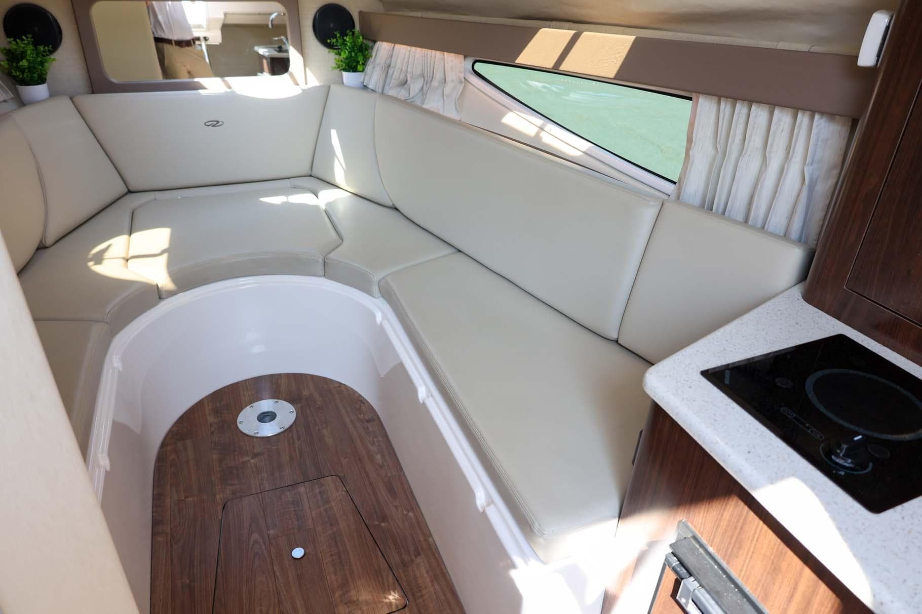 2017 Regal 28 Express cabin interior with beige seating, wood flooring, and kitchenette.