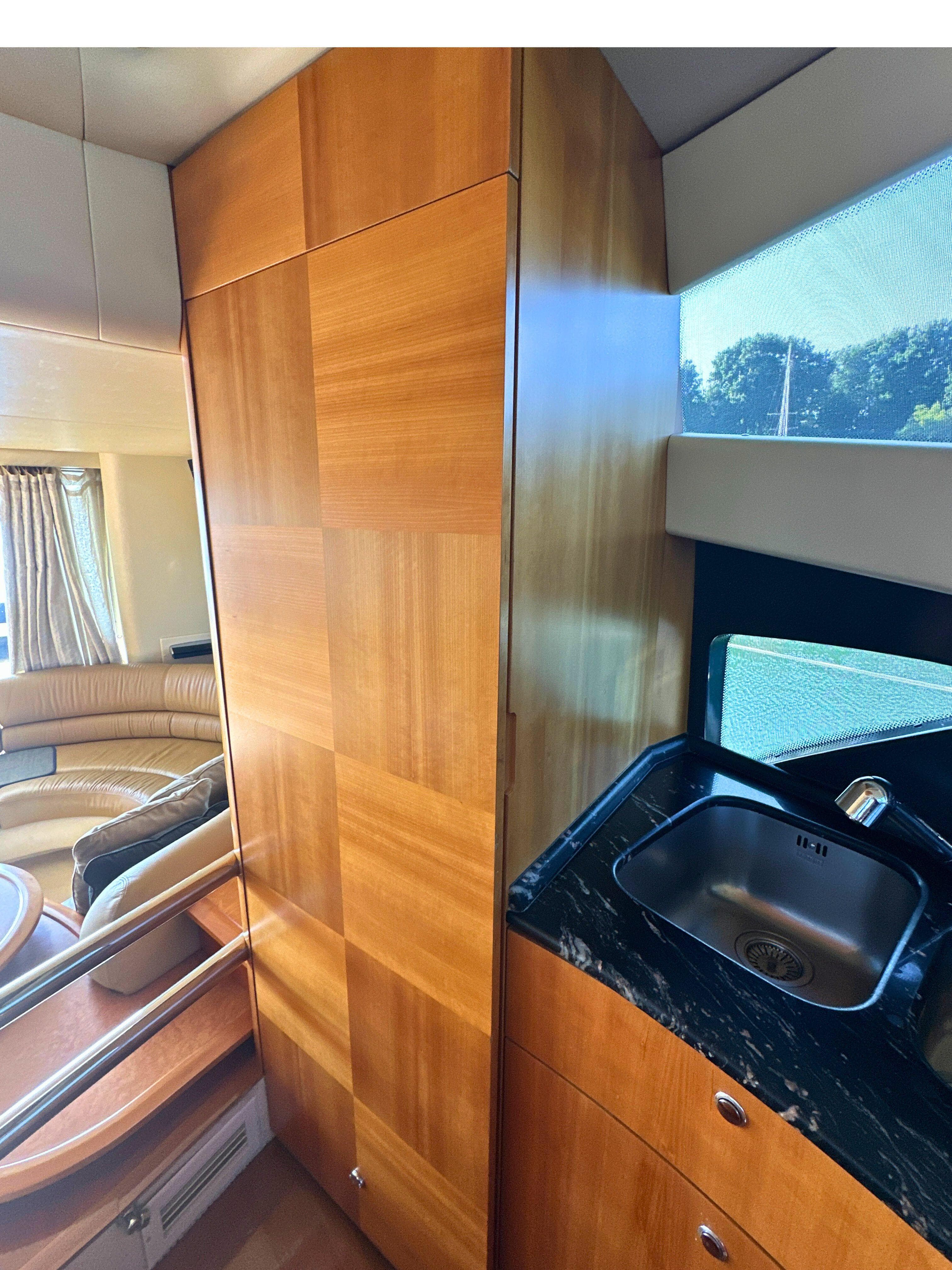 Luxurious interior of 2010 Azimut 55E yacht with wood paneling and sleek sink.