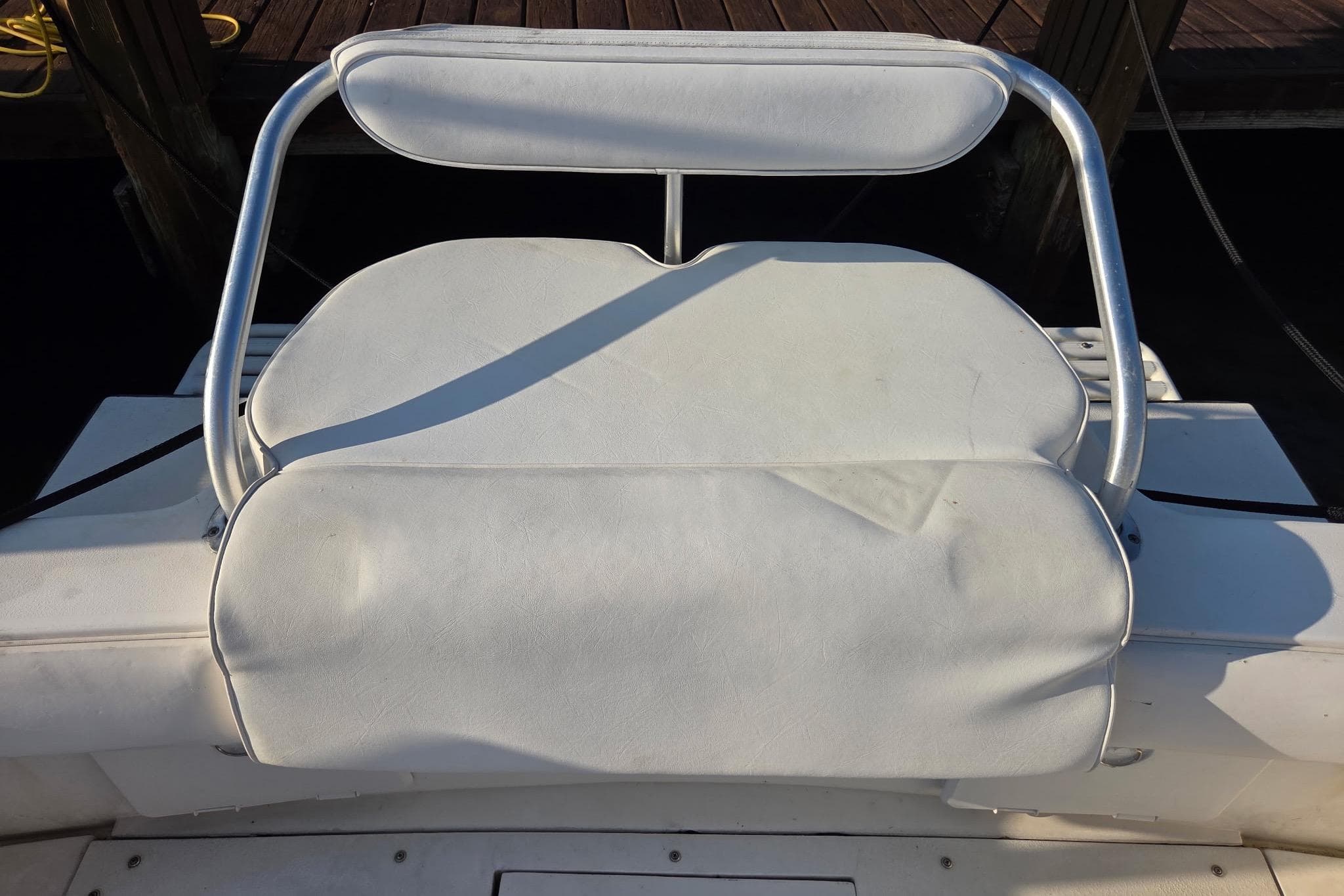White cushioned seat on a 2000 SeaVee 290B boat, docked at a marina.