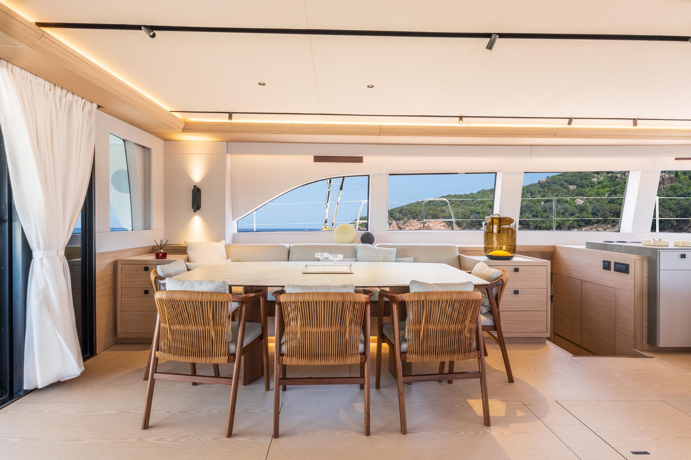 Luxurious interior of 2025 Lagoon Eighty 2 yacht with elegant dining area and scenic views.