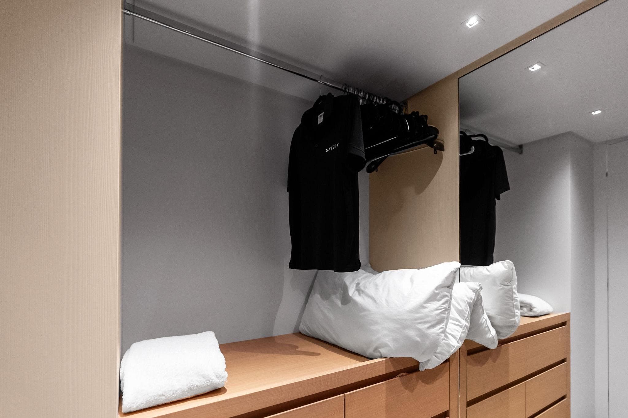 Modern closet interior on 2021 Sanlorenzo SL96A yacht with clothes and pillows.