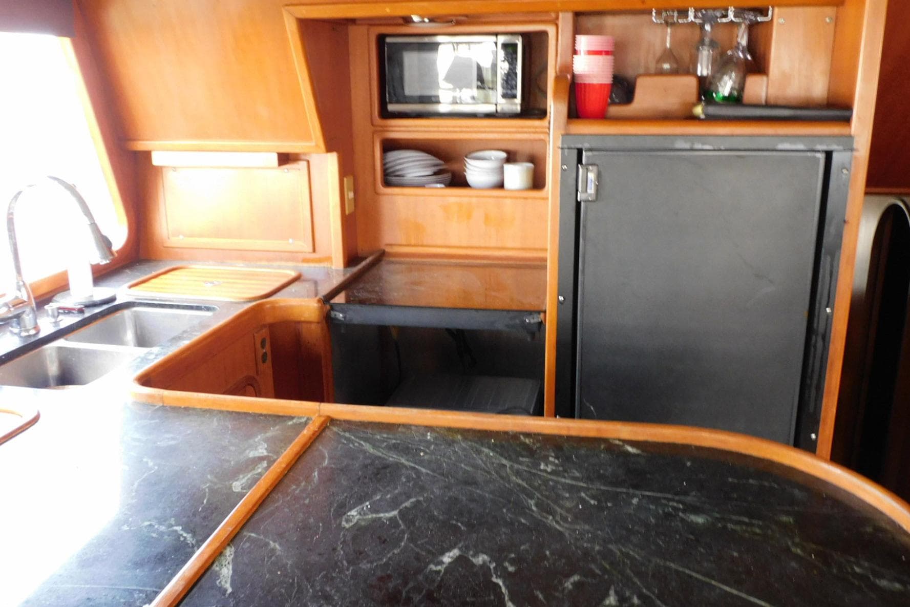 1988 Hans Christian 45 Independence Trawler kitchen with sink, microwave, and storage.