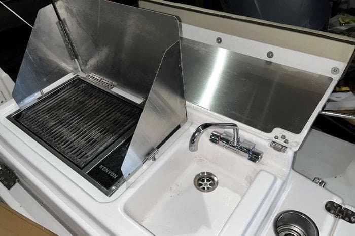 Outdoor kitchen setup on 2020 Ranger Tugs R-27 boat with grill and sink.