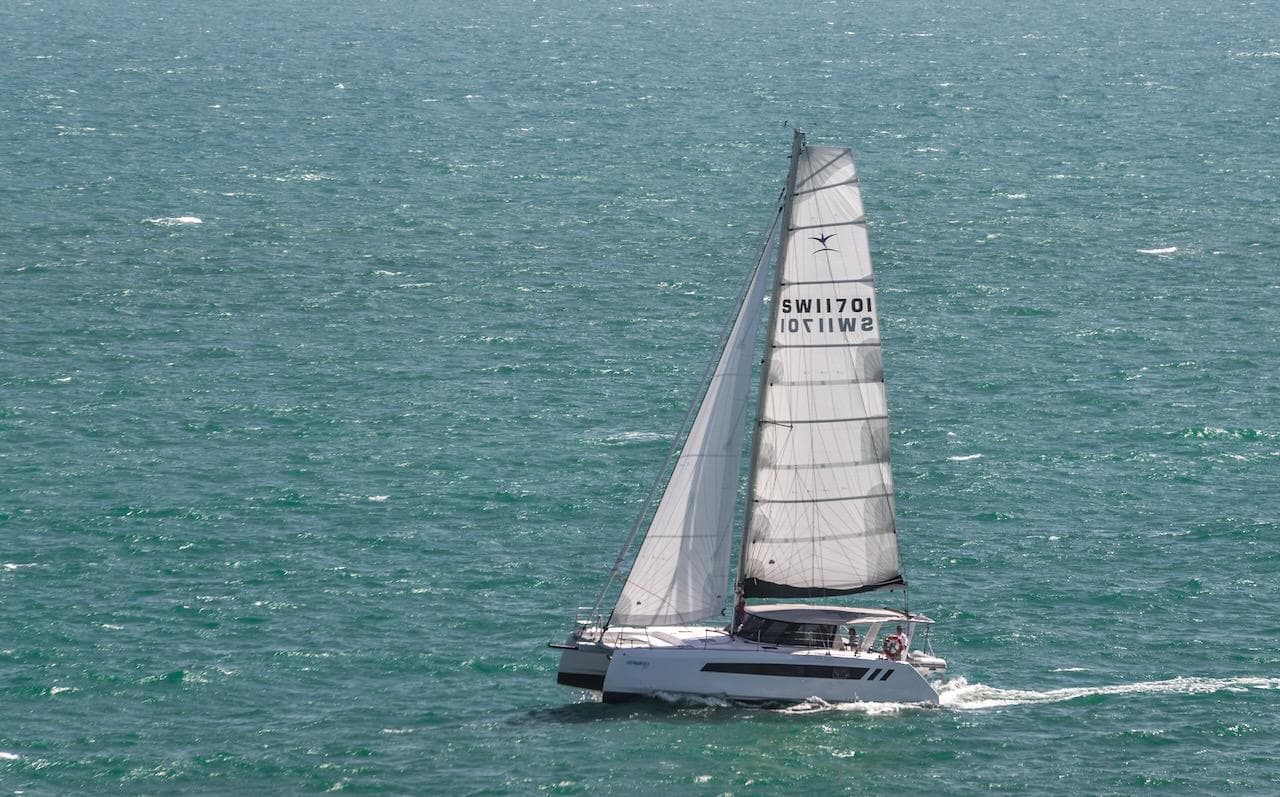2025 Seawind 1170 catamaran sailing on open sea with full sails.