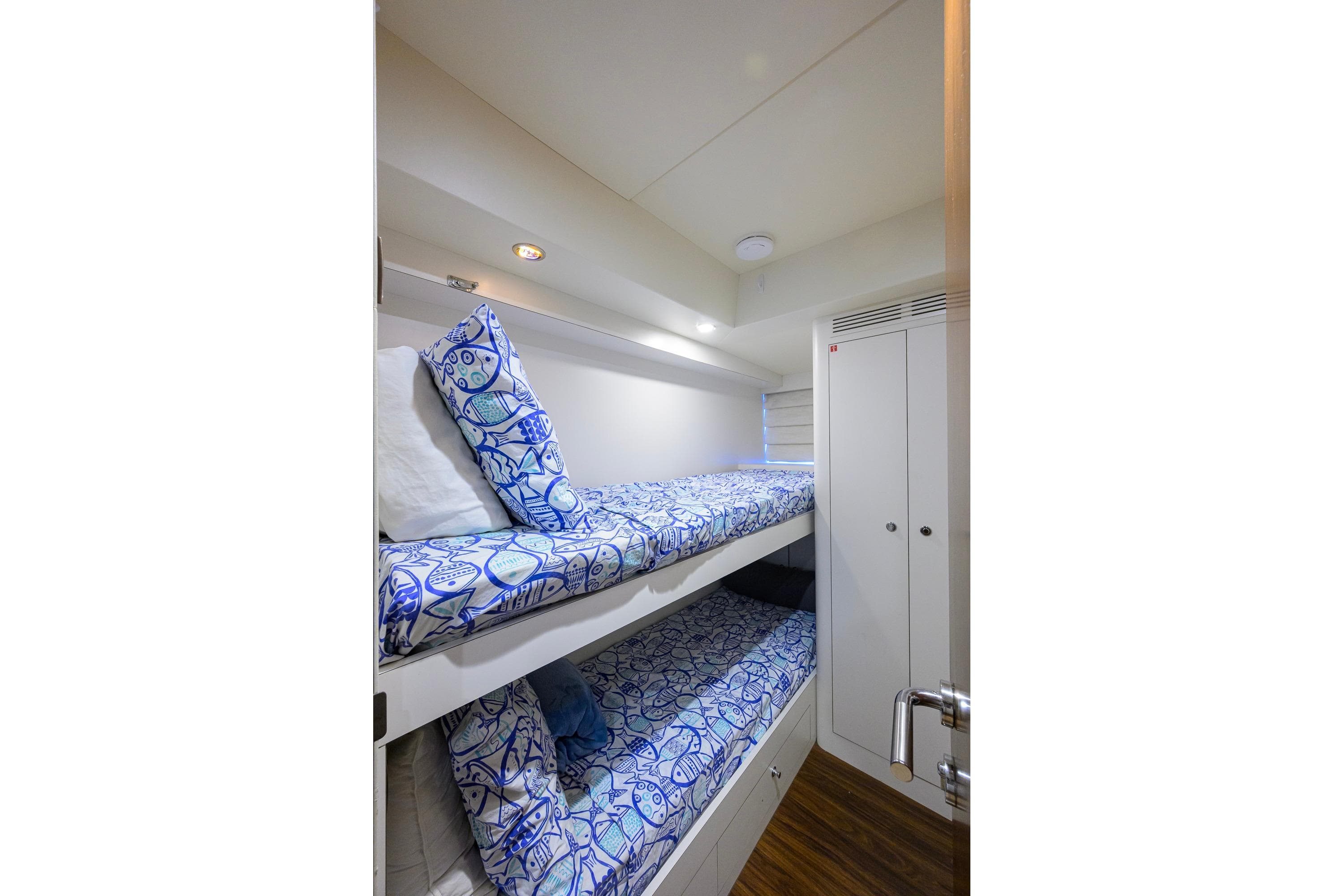 Bunk beds with blue patterned bedding in 2017 Ocean Alexander 100 Motoryacht cabin.