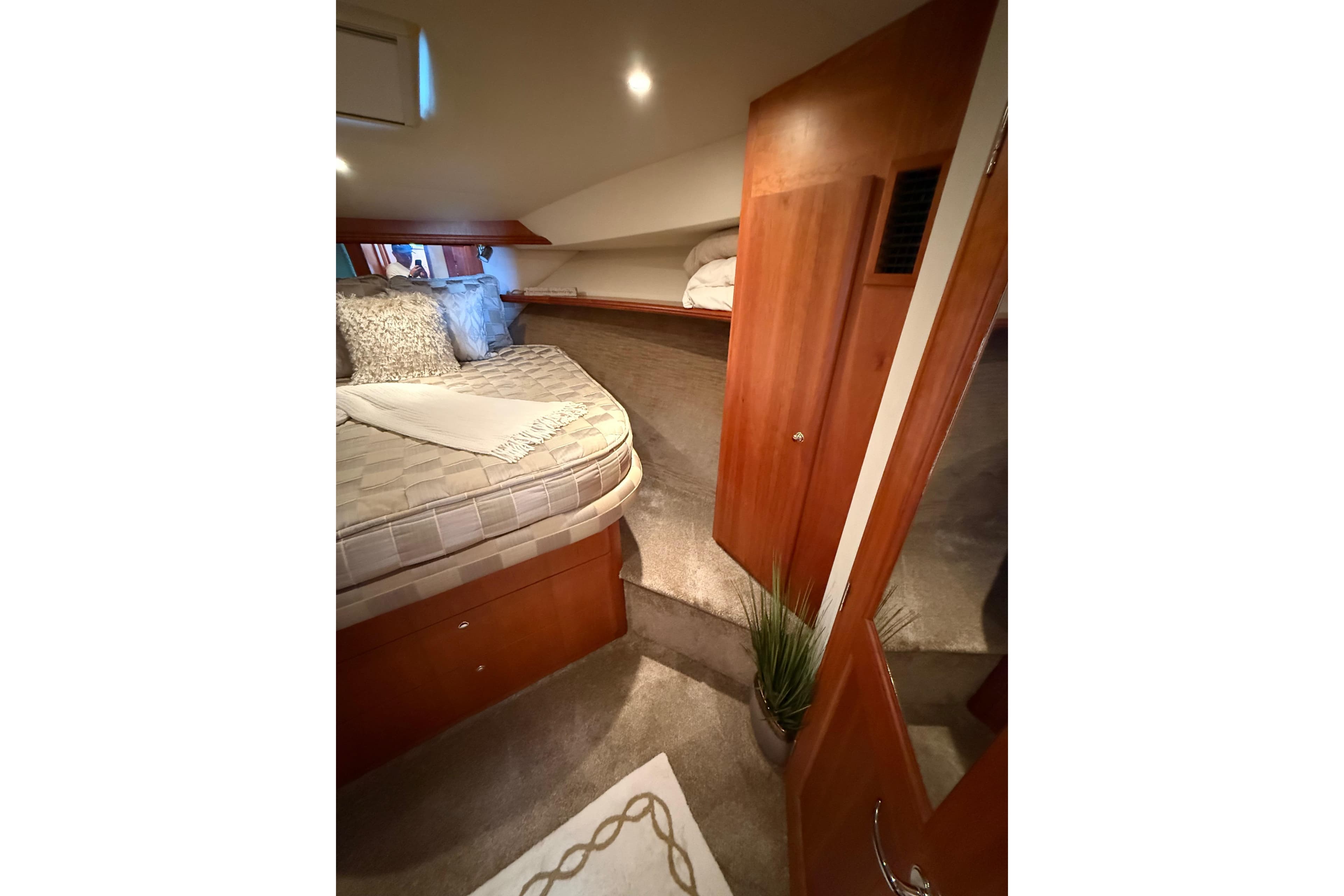 Interior cabin of 2001 Silverton 42 Convertible yacht with cozy bed and wooden accents.