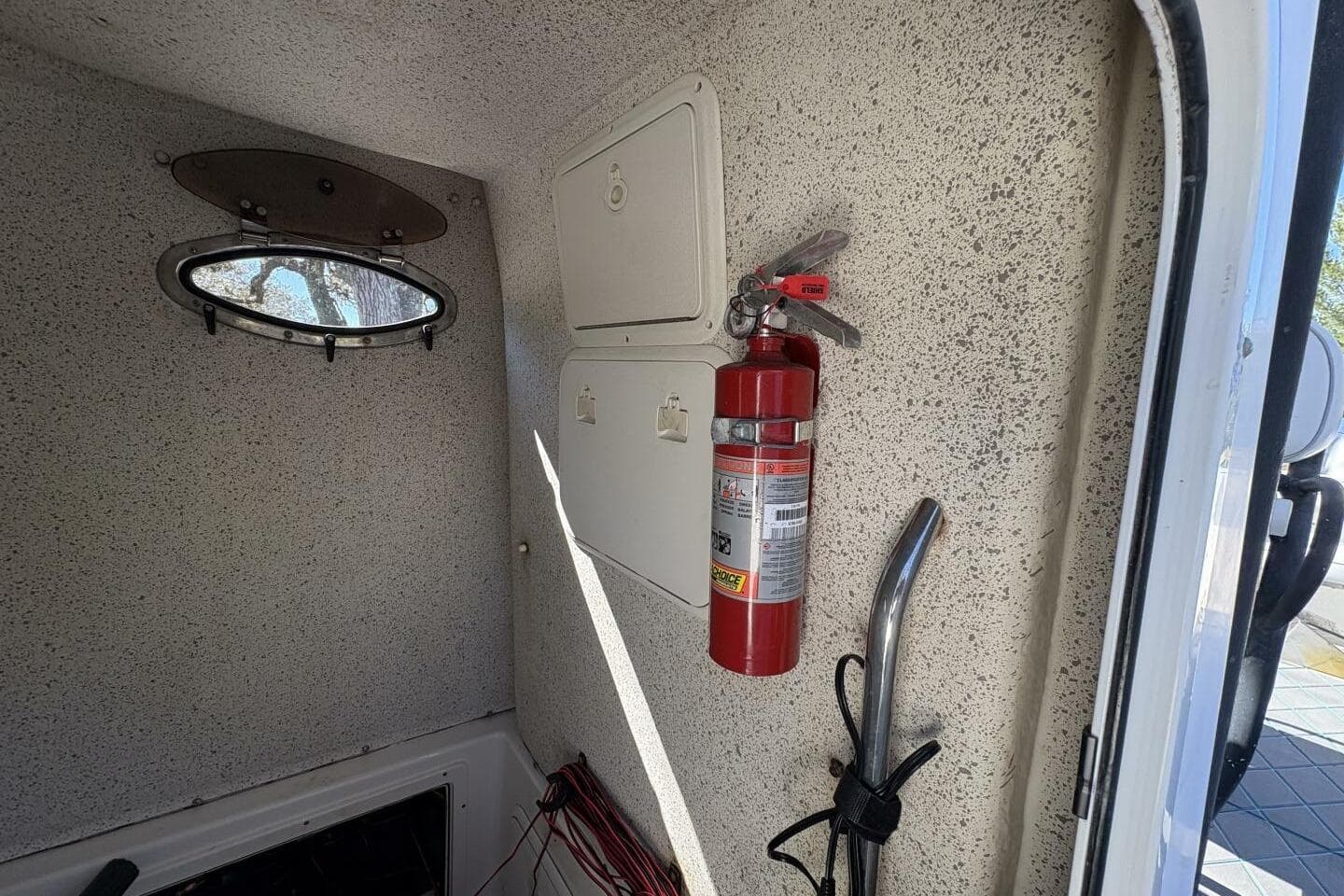 Interior of 2008 Wellcraft 35 Scarab Sport with fire extinguisher and porthole.