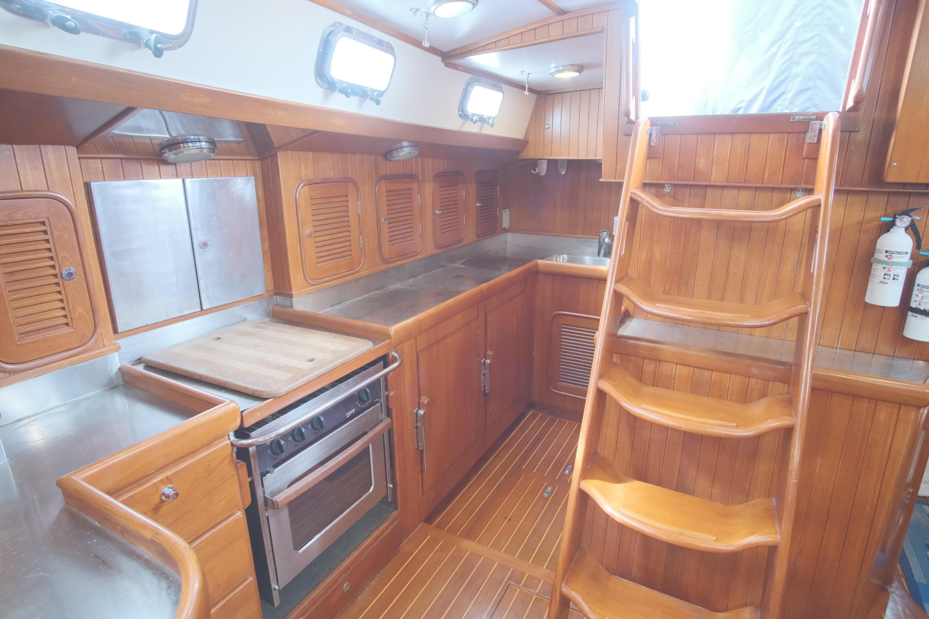 2006 Tayana Vancouver 42 yacht interior with wooden cabinetry and stainless steel kitchen appliances.