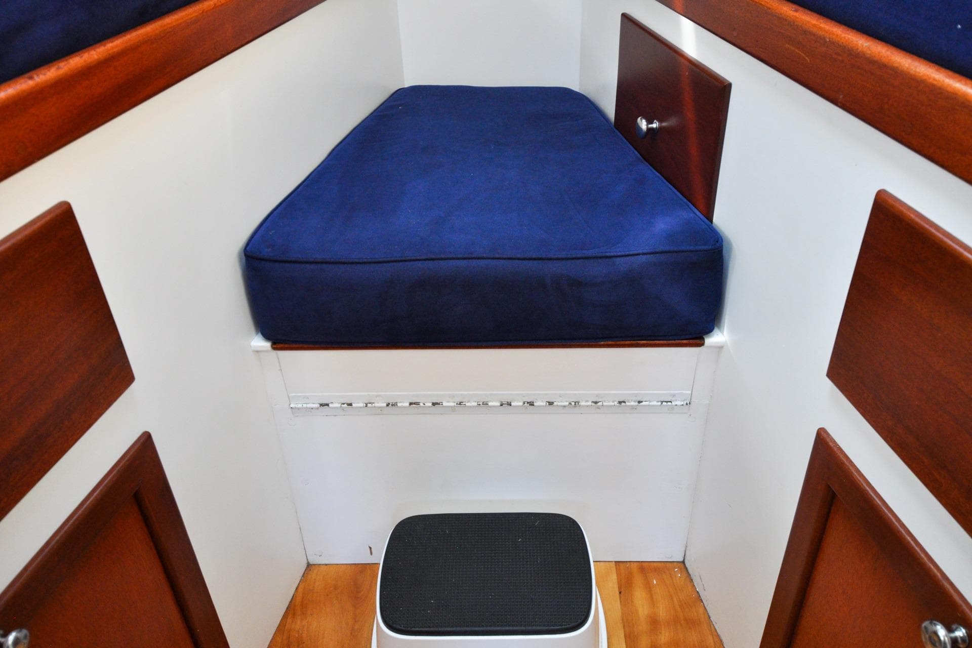 Interior cabin of a 1958 Bunker and Ellis 42 boat with blue cushion.