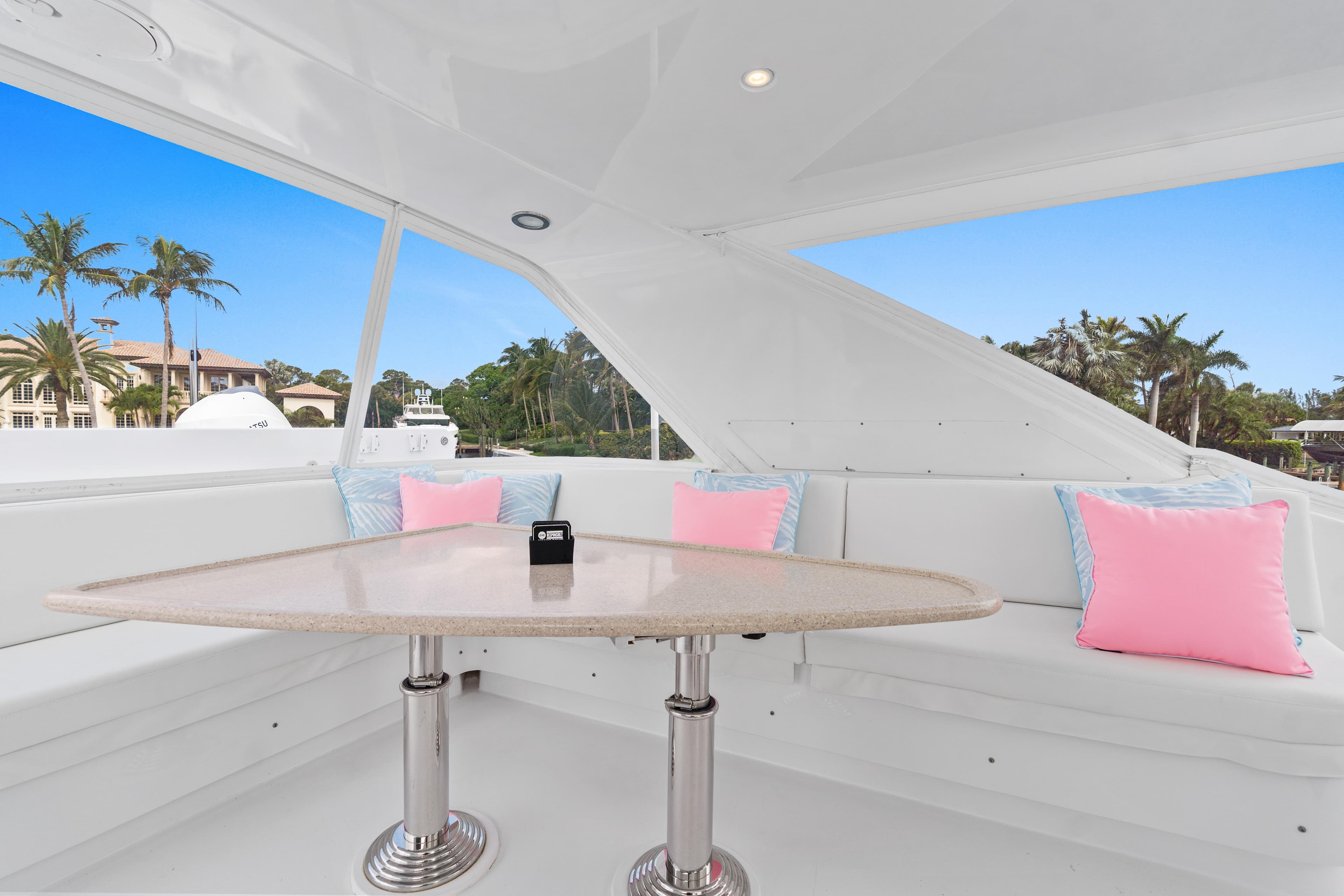 Luxurious seating area on 2008 Hatteras 64 Motor Yacht with pink and blue cushions.