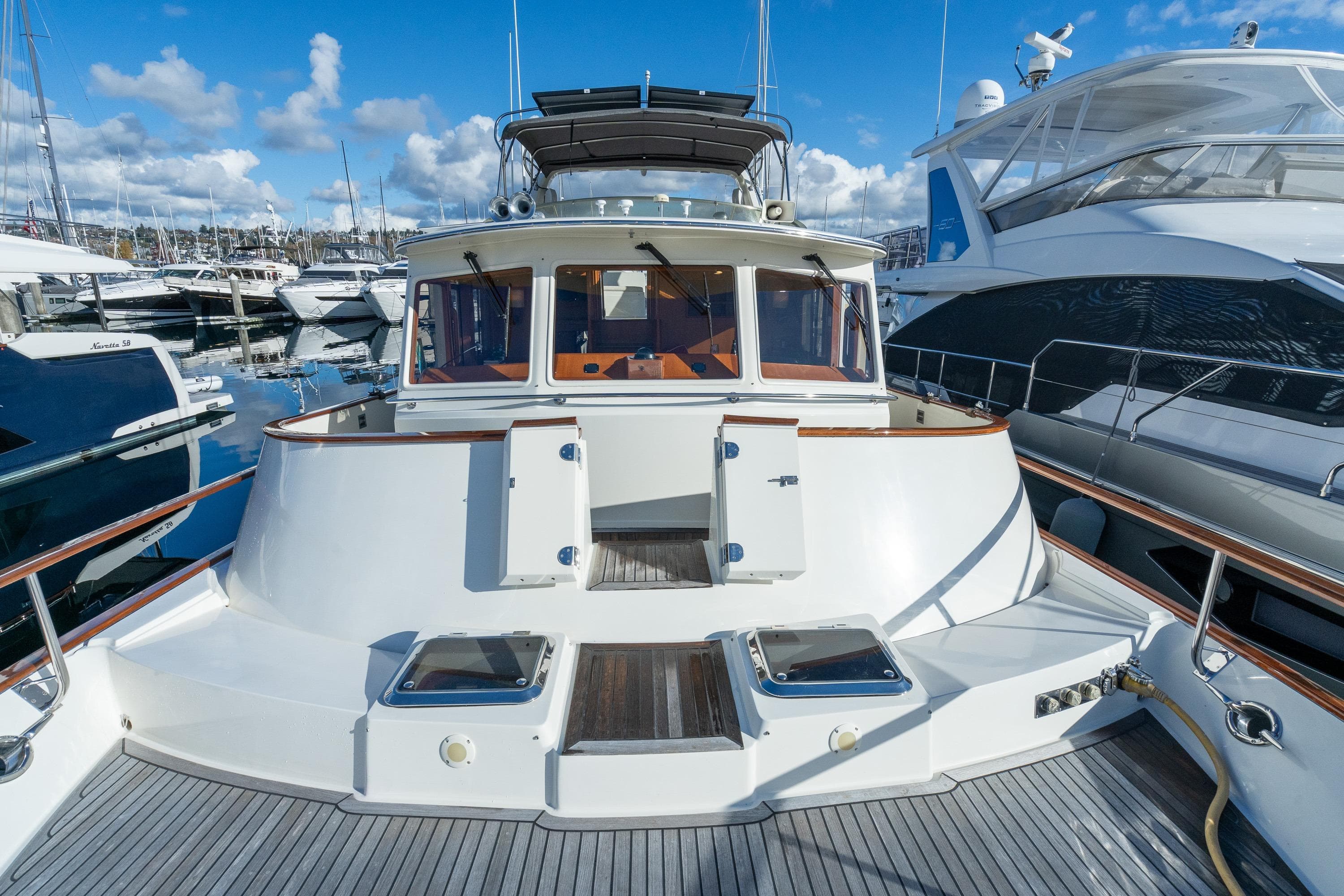 2001 Fleming 55 Pilothouse yacht docked at marina under blue sky.