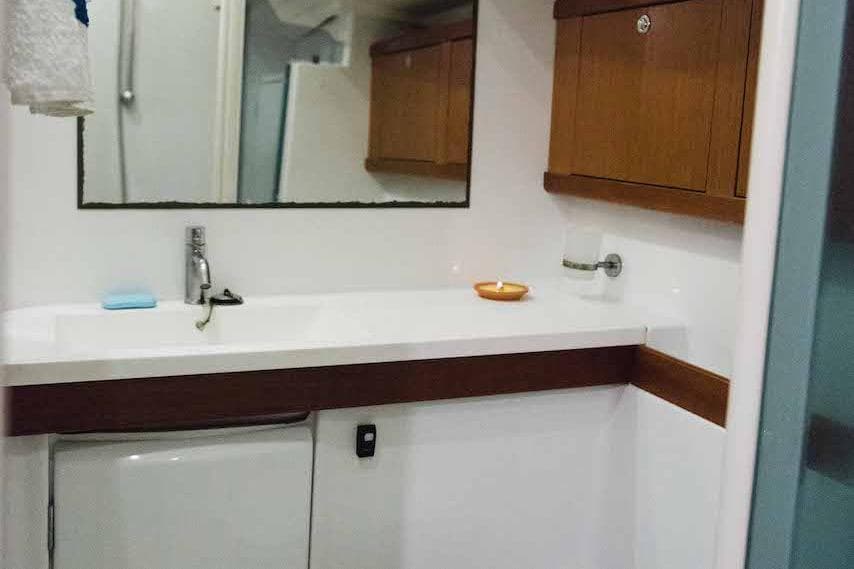 Bathroom interior of 2009 Beneteau Oceanis 54 yacht with wooden cabinets and mirror.