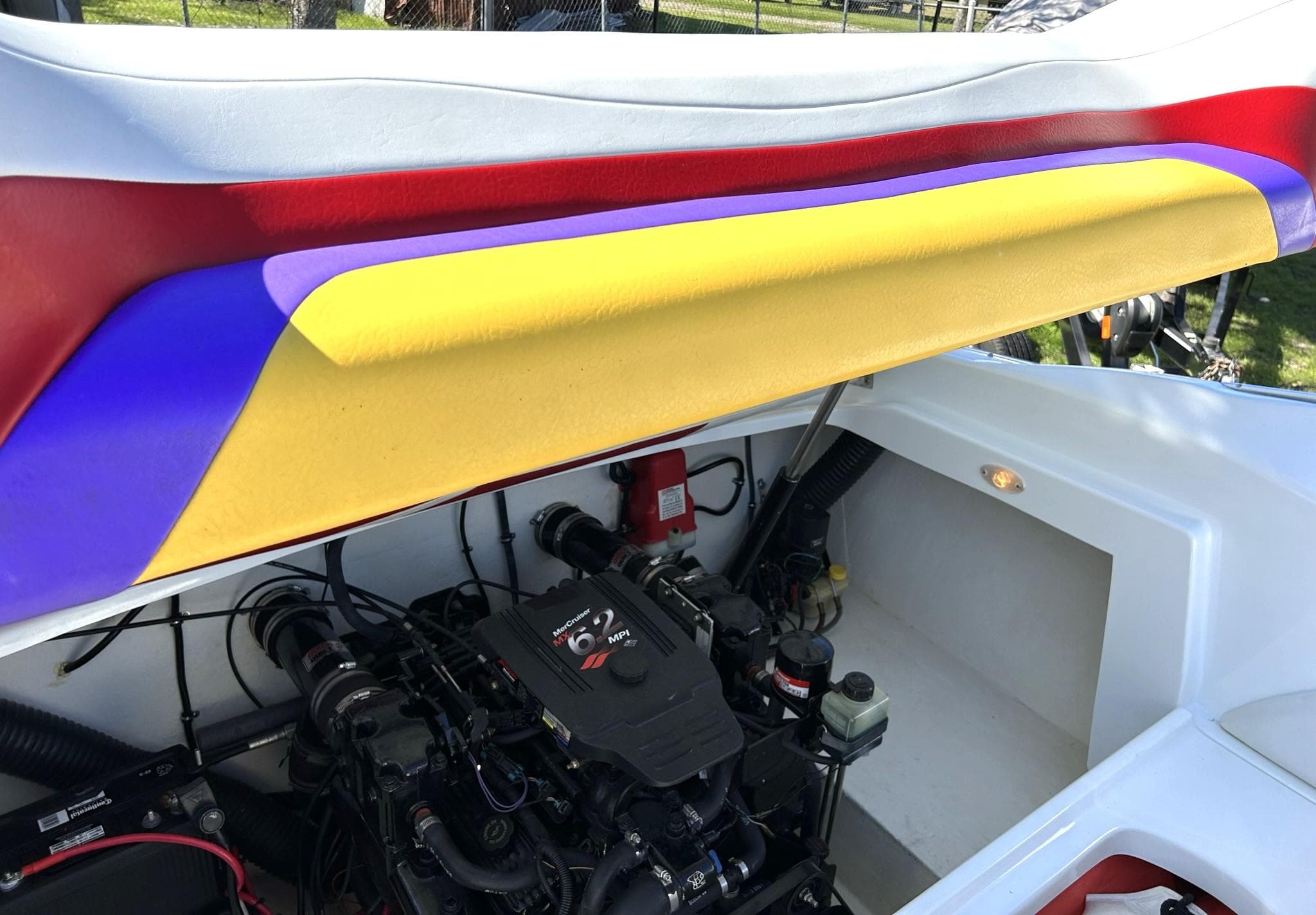 Engine compartment of a 2002 Baja 232 boat with colorful interior accents.