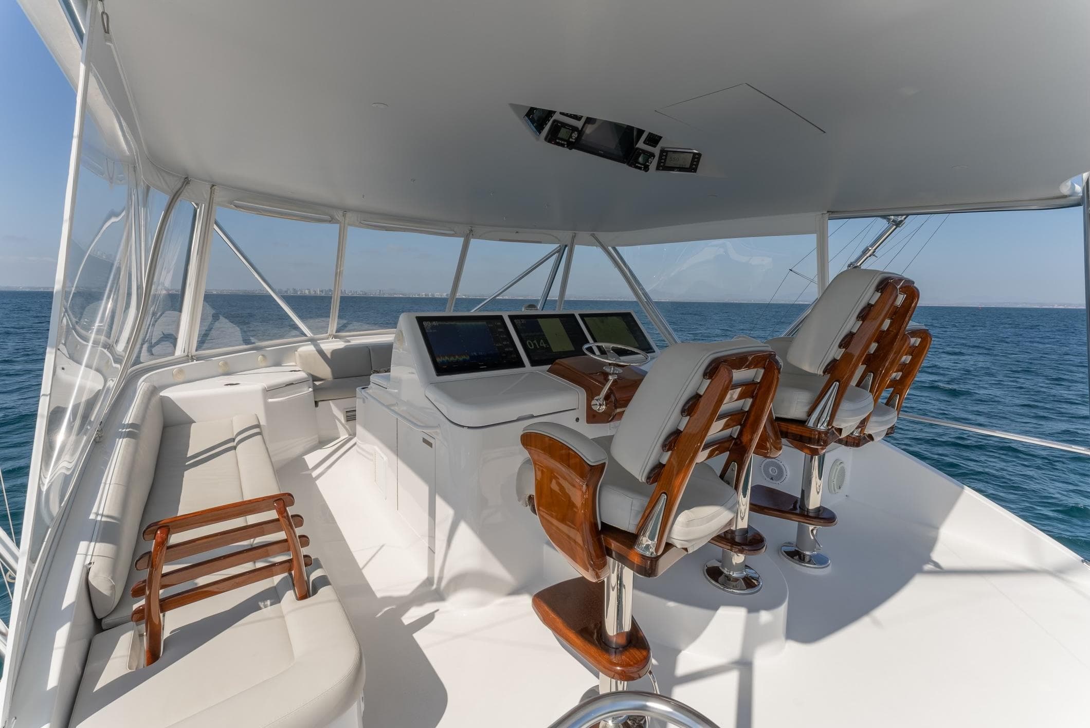 2018 Hatteras GT70 yacht helm with luxurious seating and ocean view.