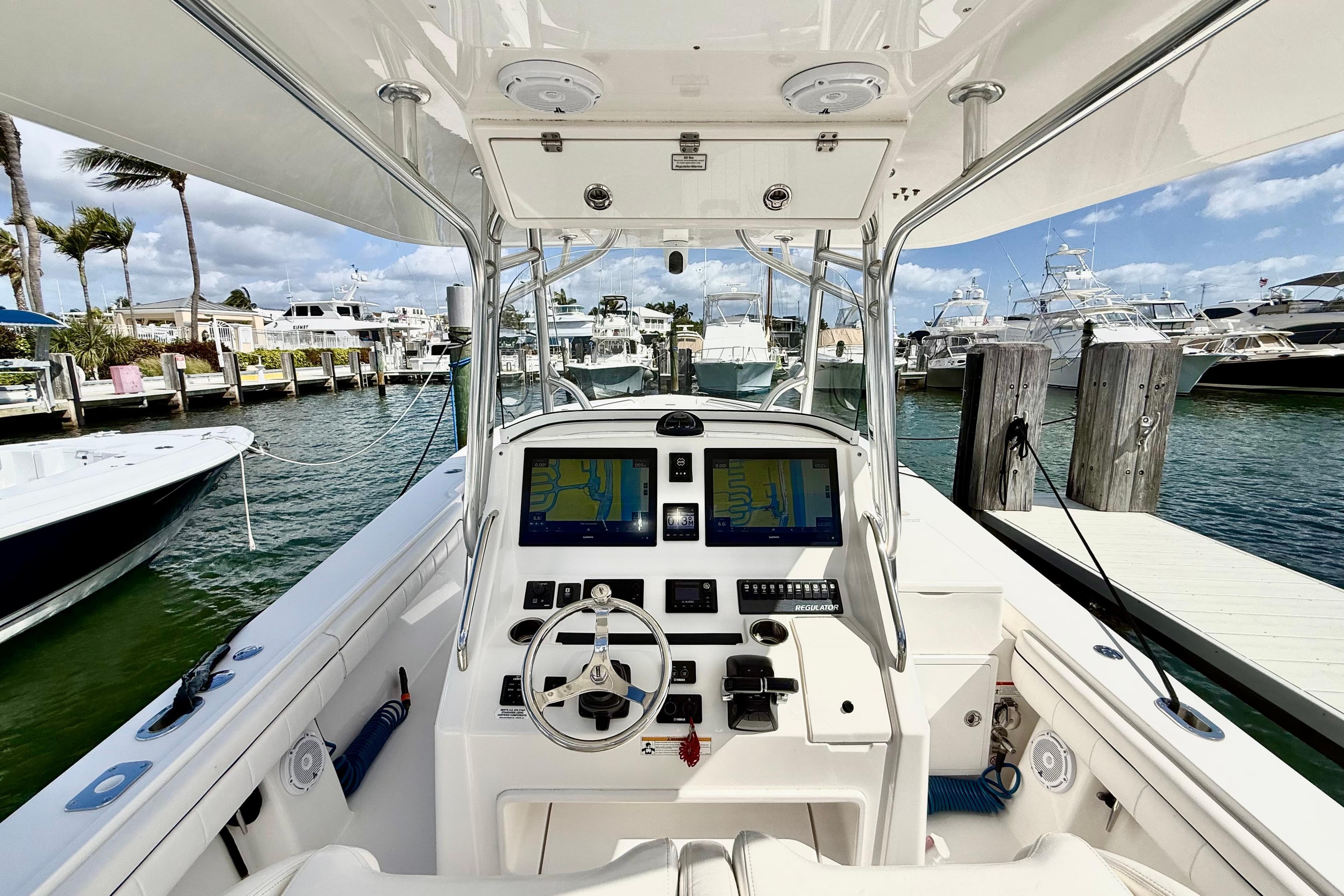 2016 Regulator 34SS boat dashboard with navigation screens, docked at a marina.