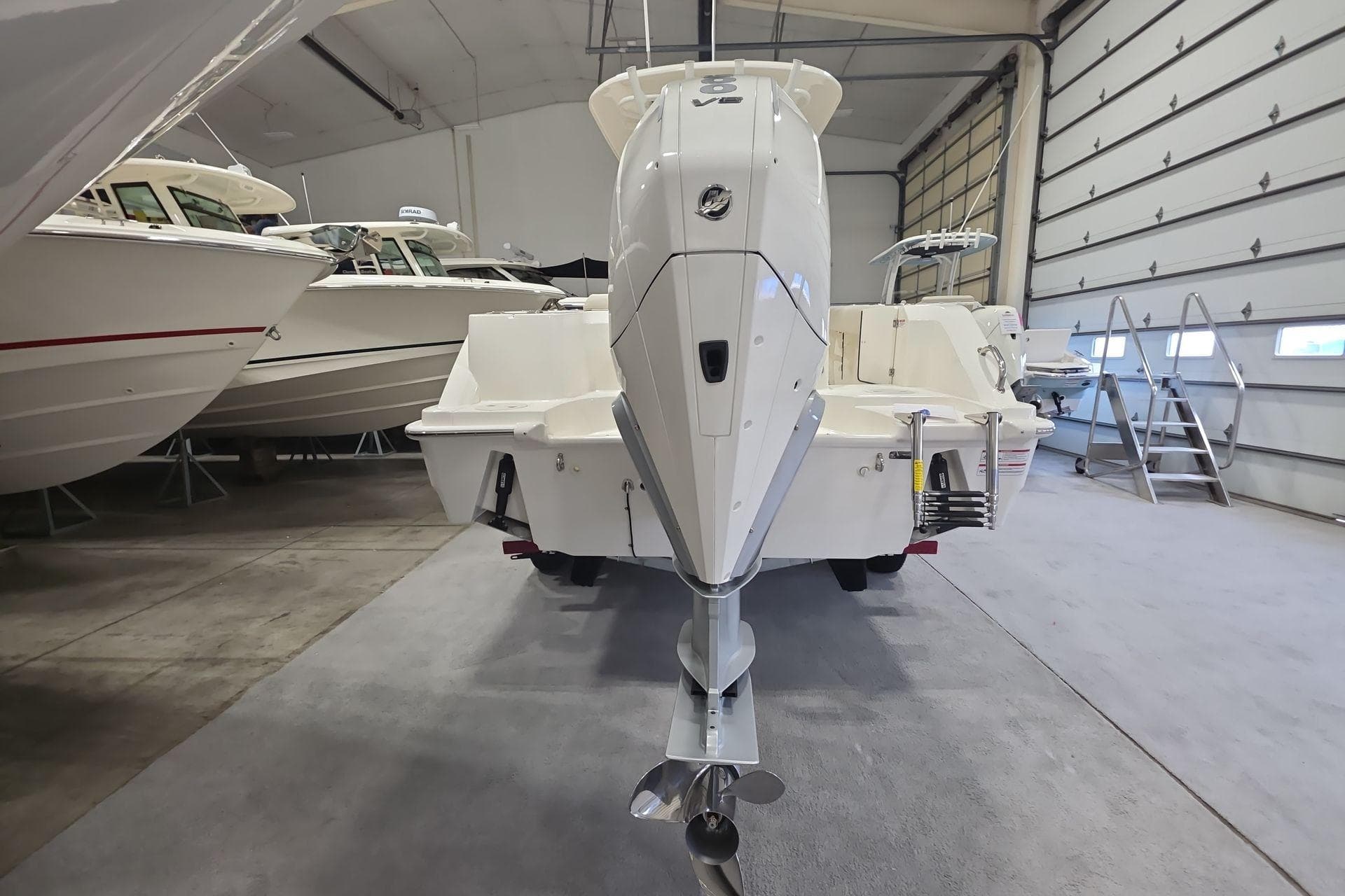 2026 Boston Whaler 230 Outrage boat in indoor storage, rear view.