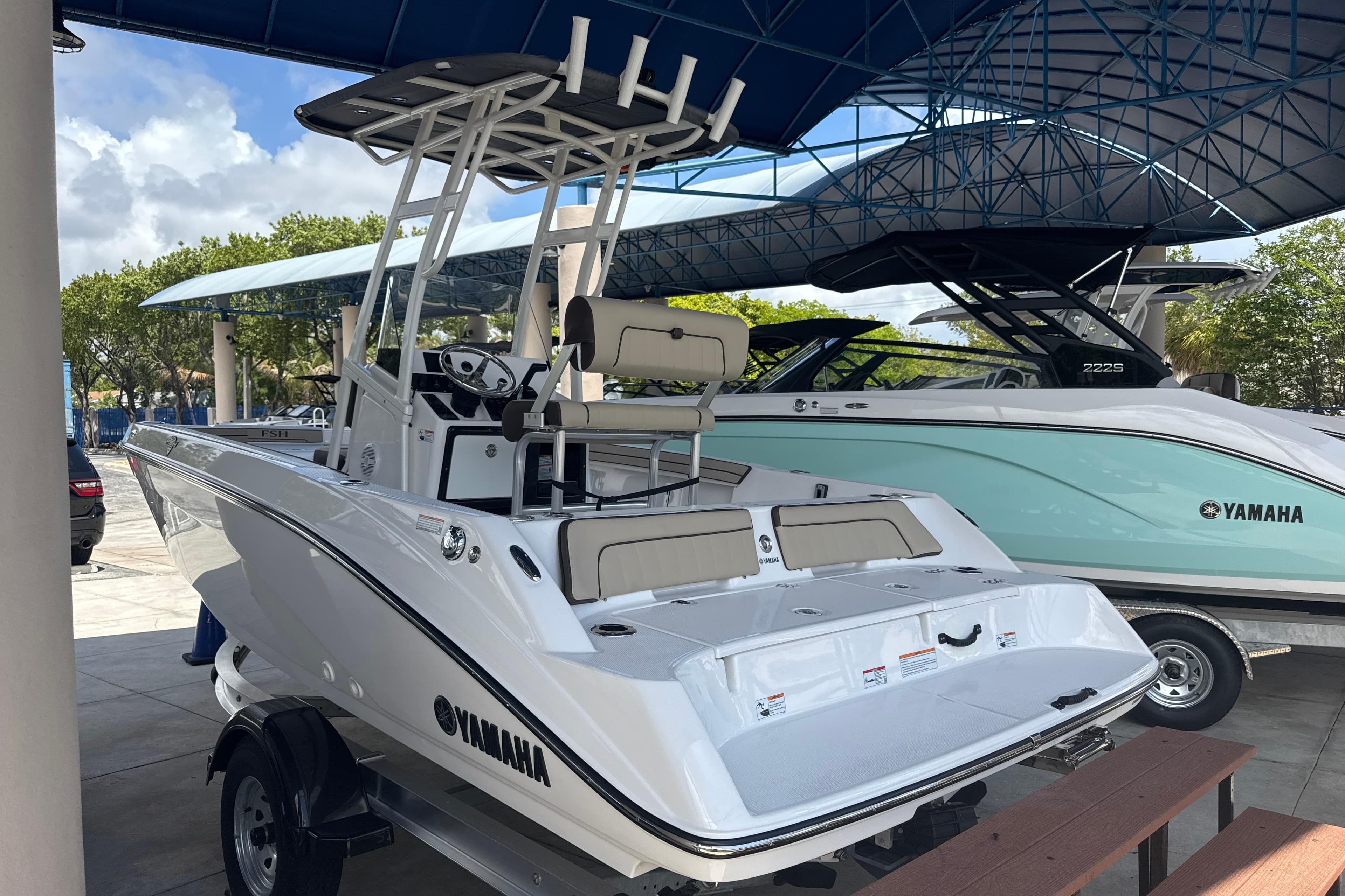 2026 Yamaha Boats 195 FSH Sport displayed in a showroom, highlighting sleek design and features.