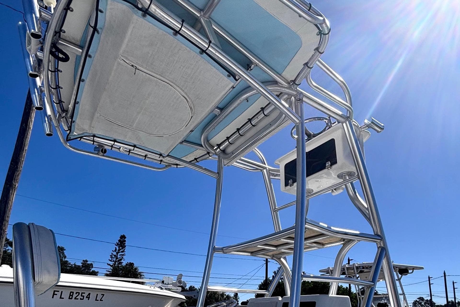 1974 Aquasport 2400 Center Console boat with T-top under clear blue sky.