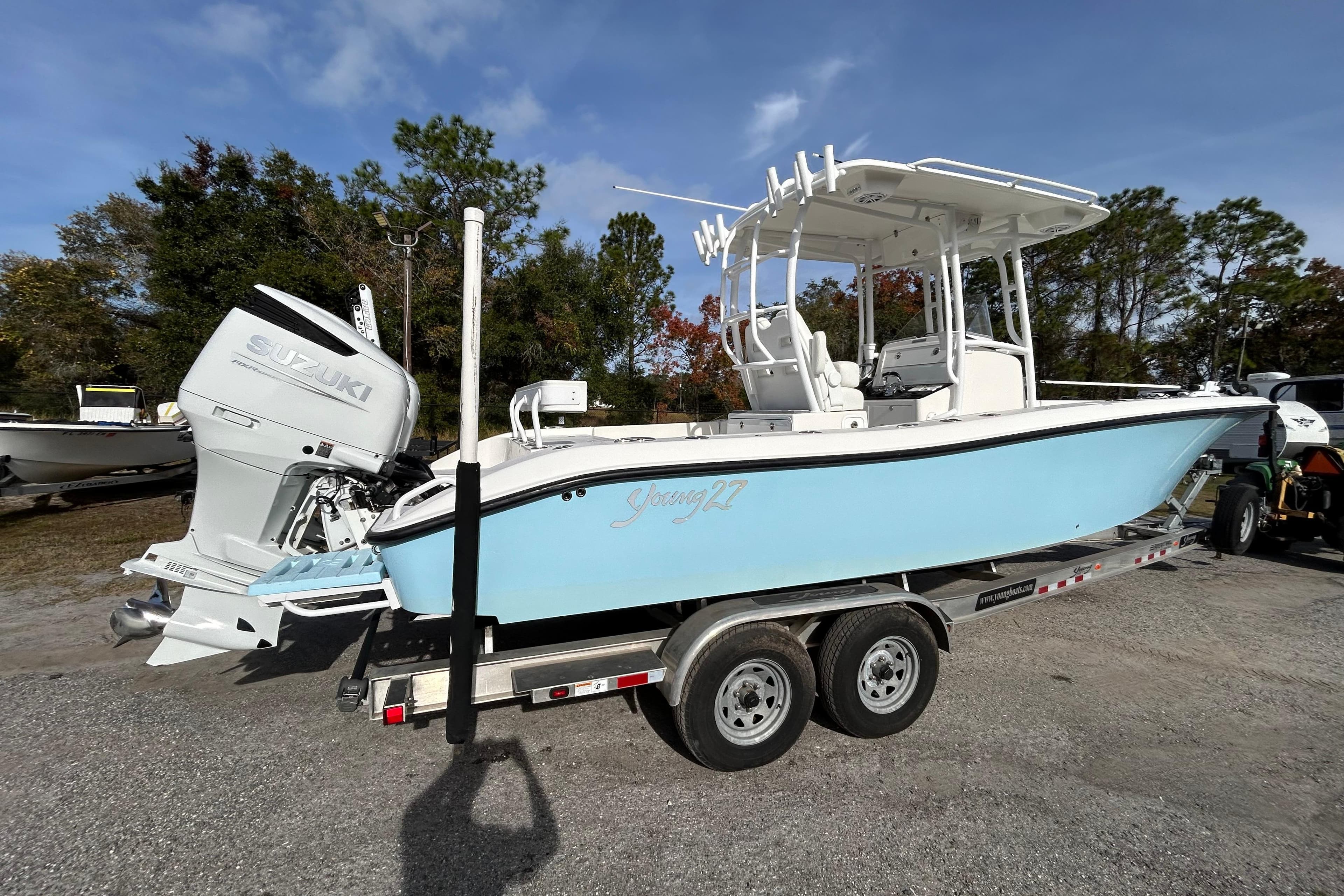 2022 Young Boats 27 on trailer with Suzuki outboard, parked outdoors.