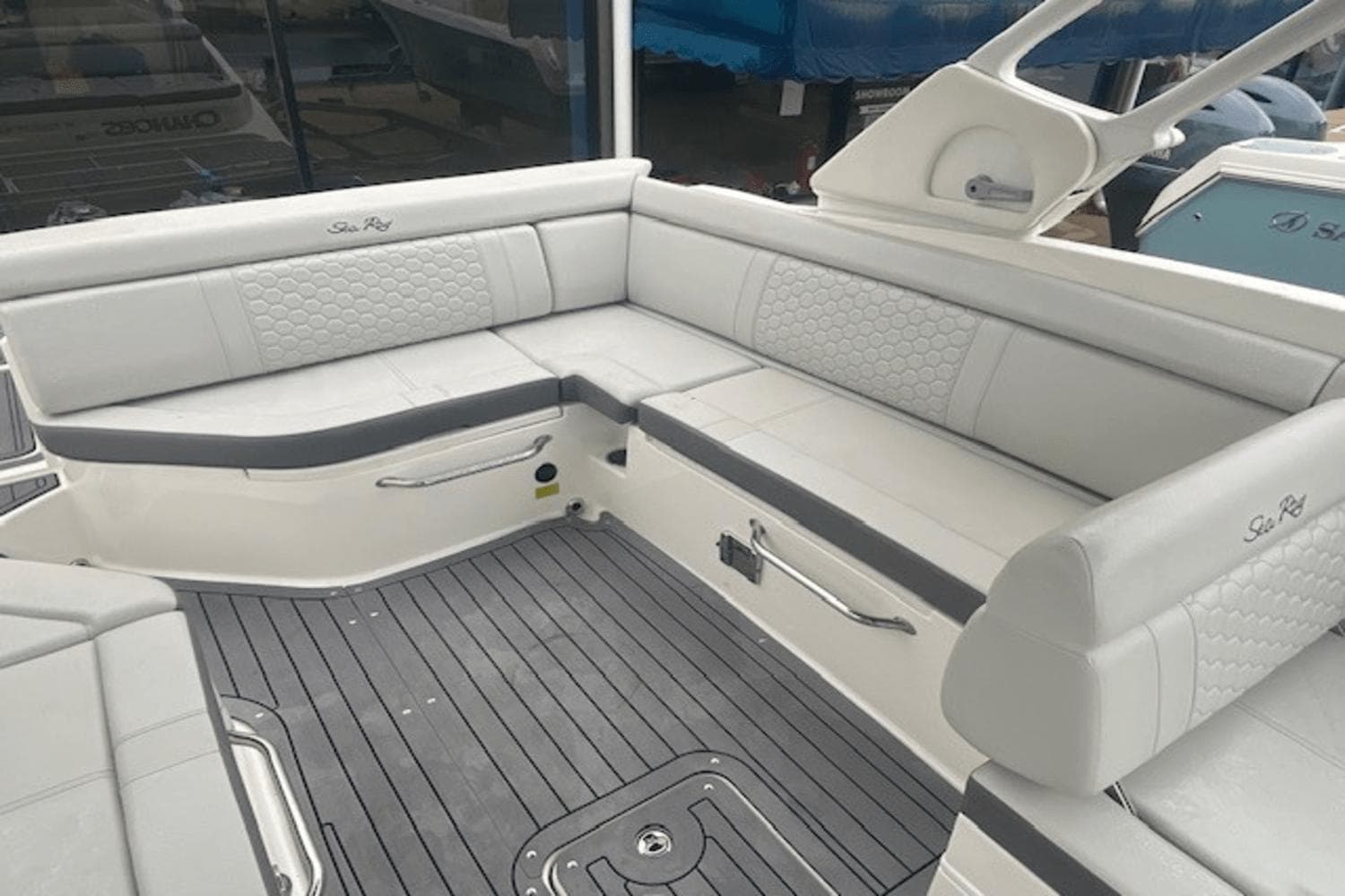 2021 Sea Ray SDX 270 boat interior with white cushioned seating and gray flooring.