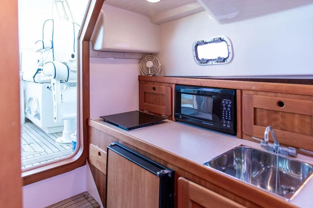 2008 Hunt Yachts Surfhunter 29 interior with kitchenette, microwave, and sink.