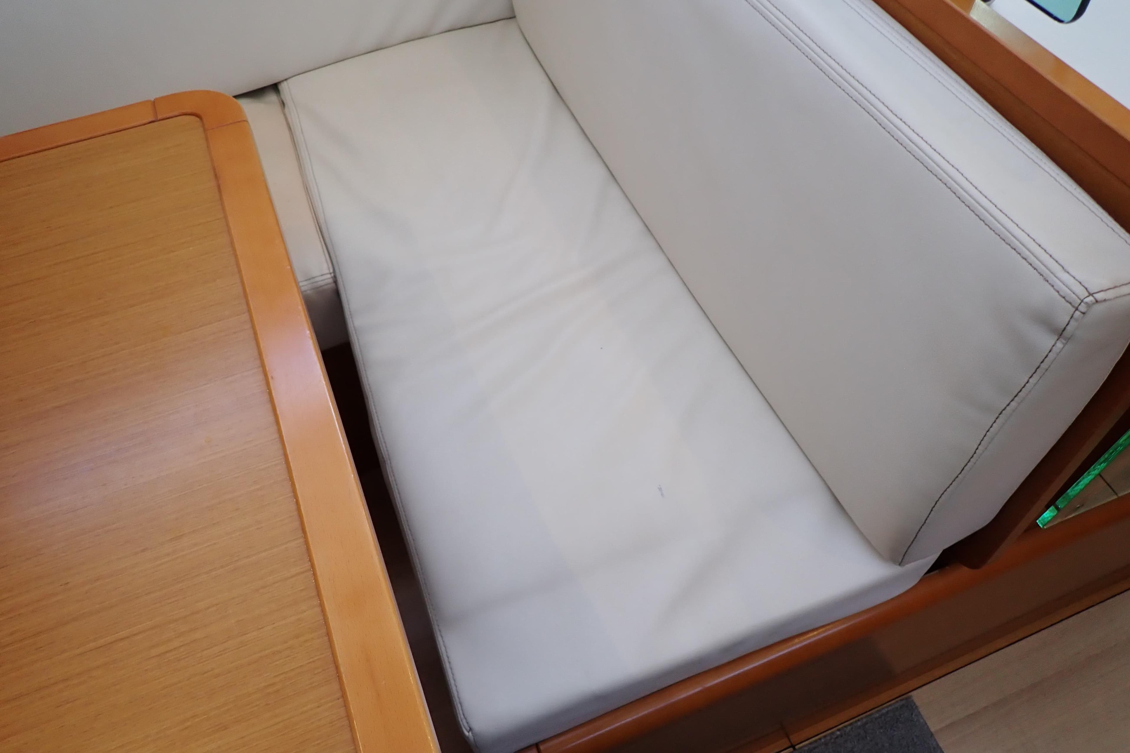 Interior seating of 2018 Jeanneau Sun Odyssey 389 yacht with wooden table.