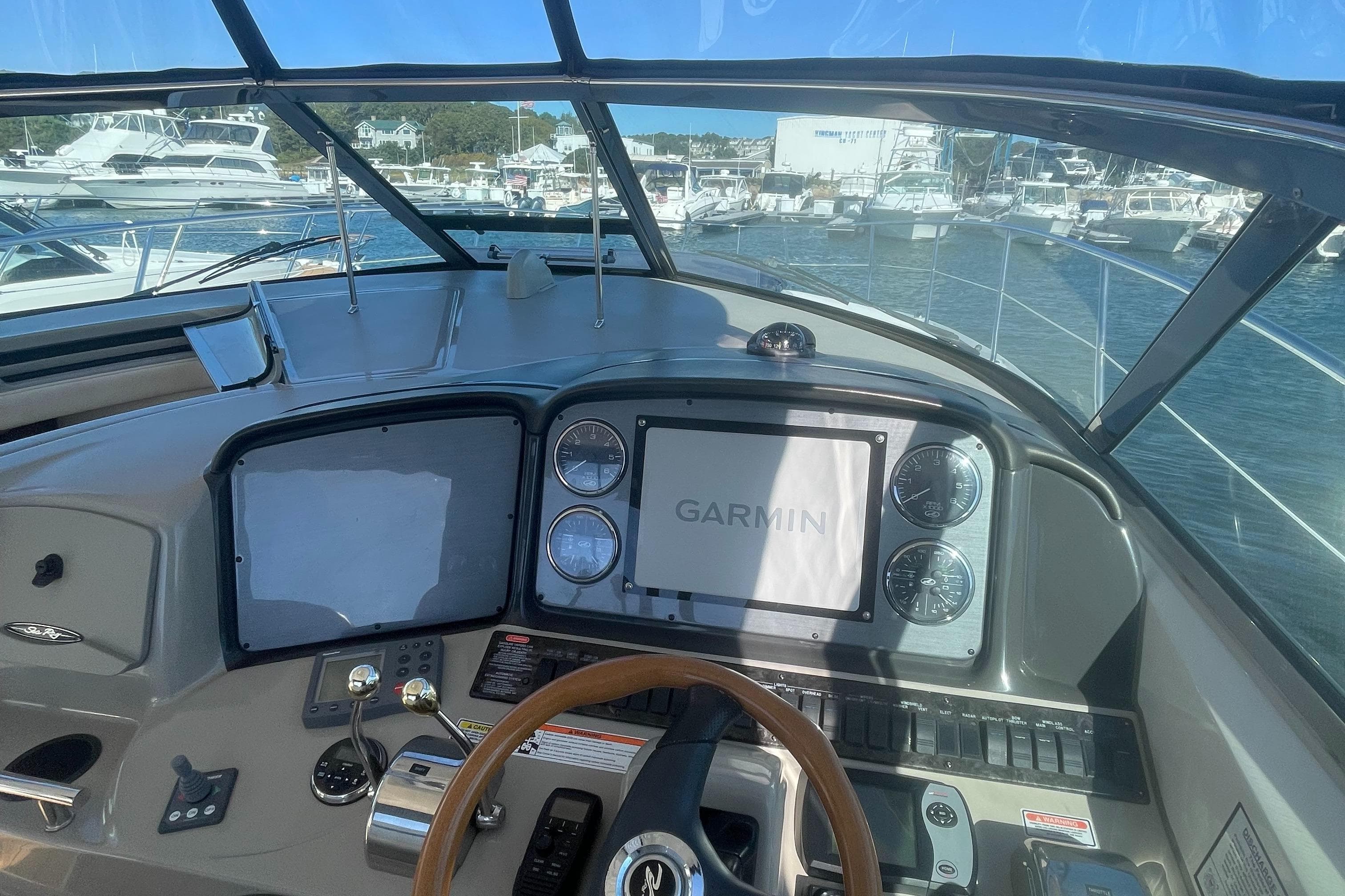 Helm of 2006 Sea Ray 380 Sundancer with Garmin navigation system, docked at marina.