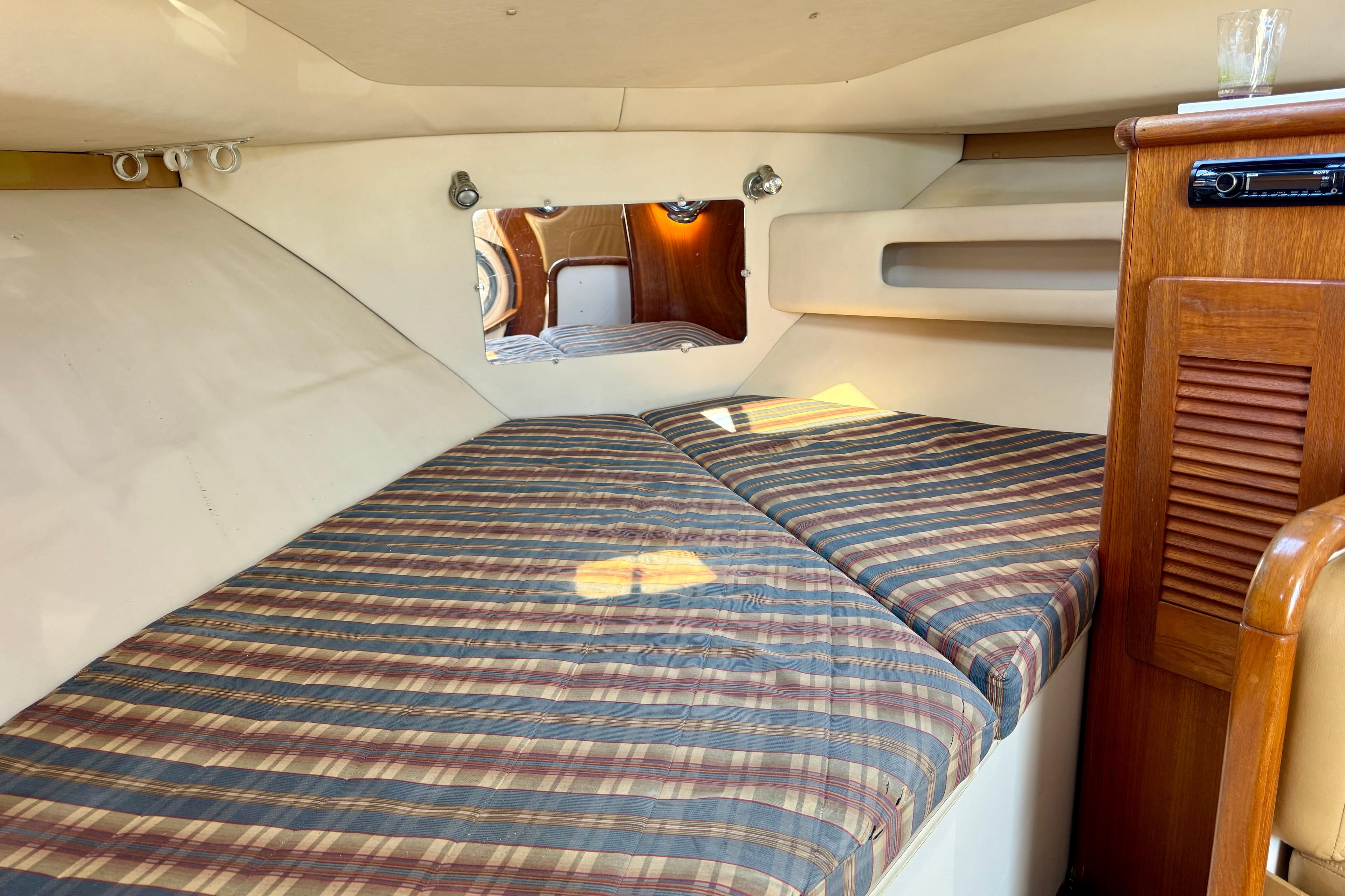 2000 Pursuit 3000 Express cabin interior with striped bedding and wooden cabinetry.