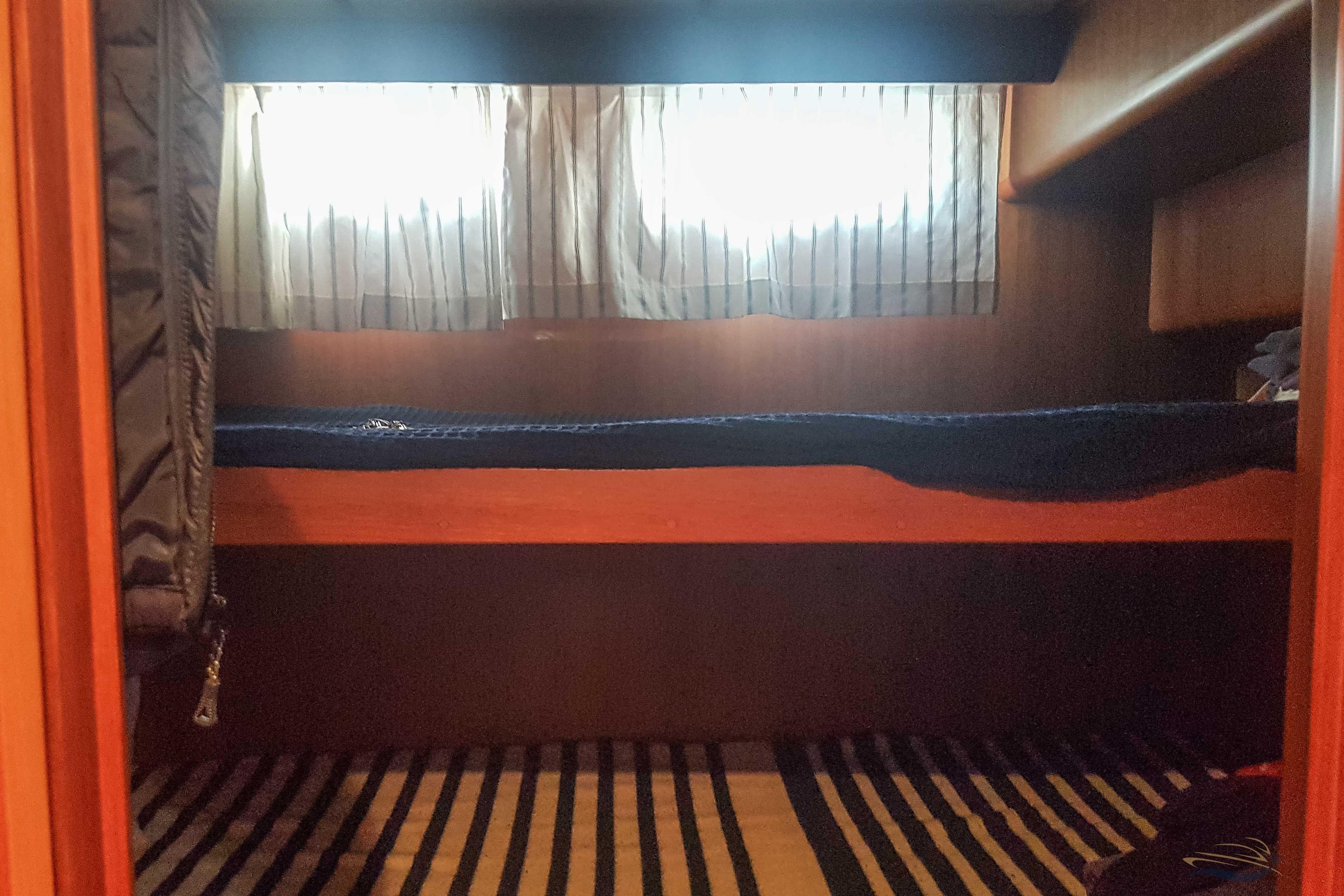 Cozy cabin interior of 2009 Adagio 51.5 Europa yacht with bunk beds and striped bedding.