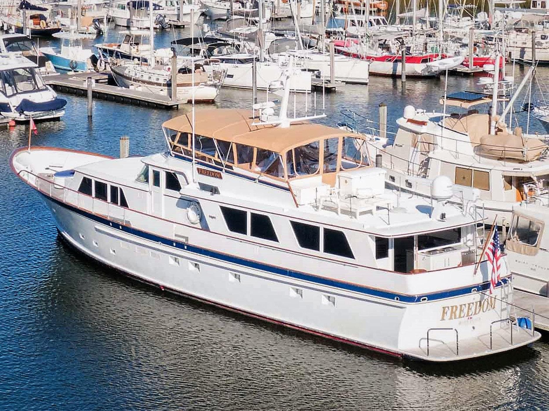 1979 Burger Raised Pilothouse yacht docked in a marina, surrounded by other boats.