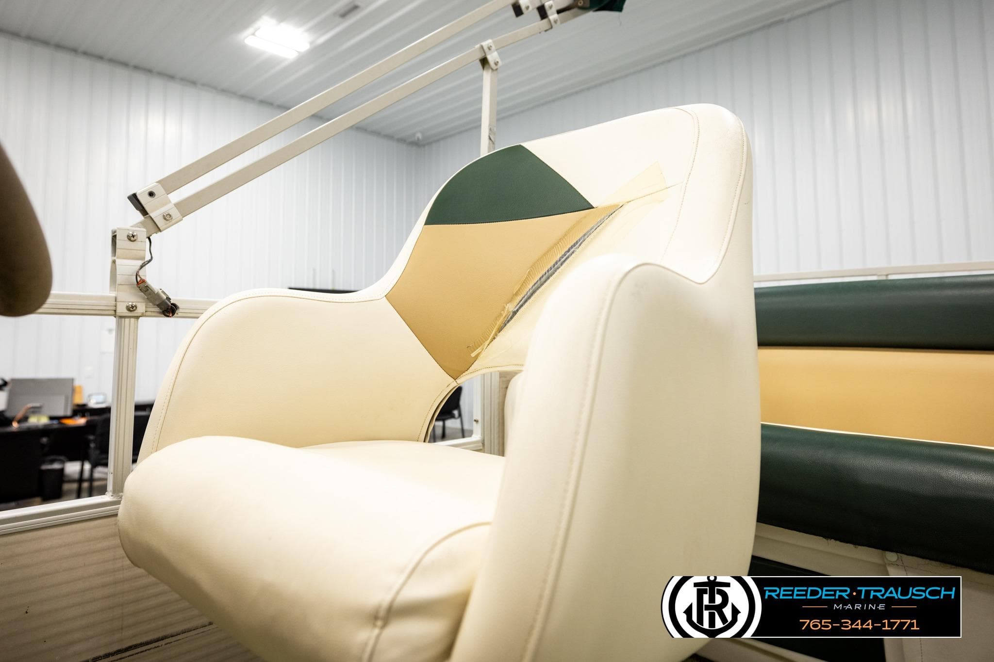 White and tan boat seat on a 2003 Godfrey Sweetwater 60, indoor setting.