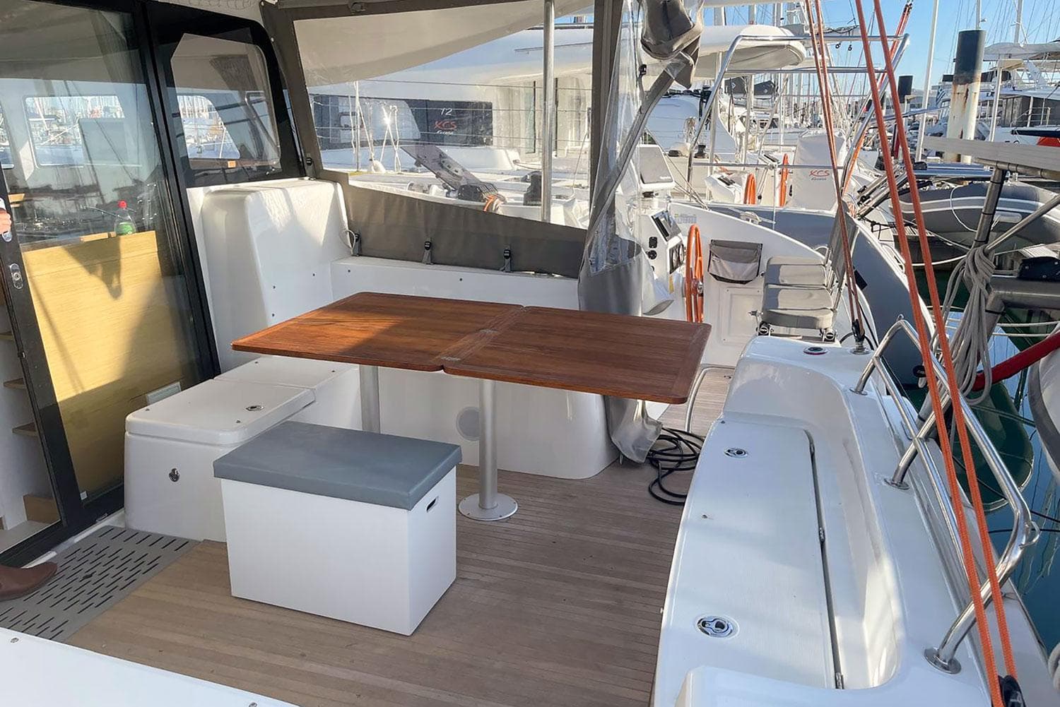 Spacious deck of 2020 Excess 11 catamaran with wooden table and seating.