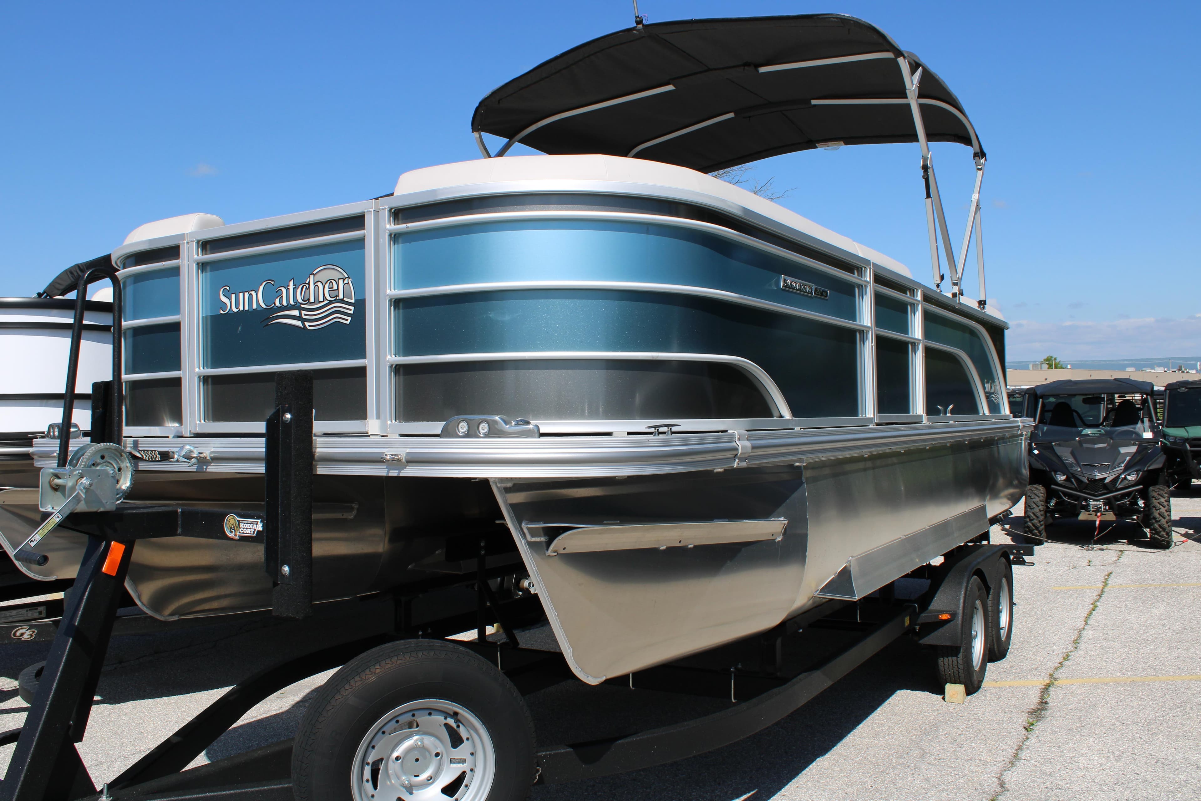 2024 SunCatcher Select 22RC pontoon boat on trailer, featuring sleek design and canopy.