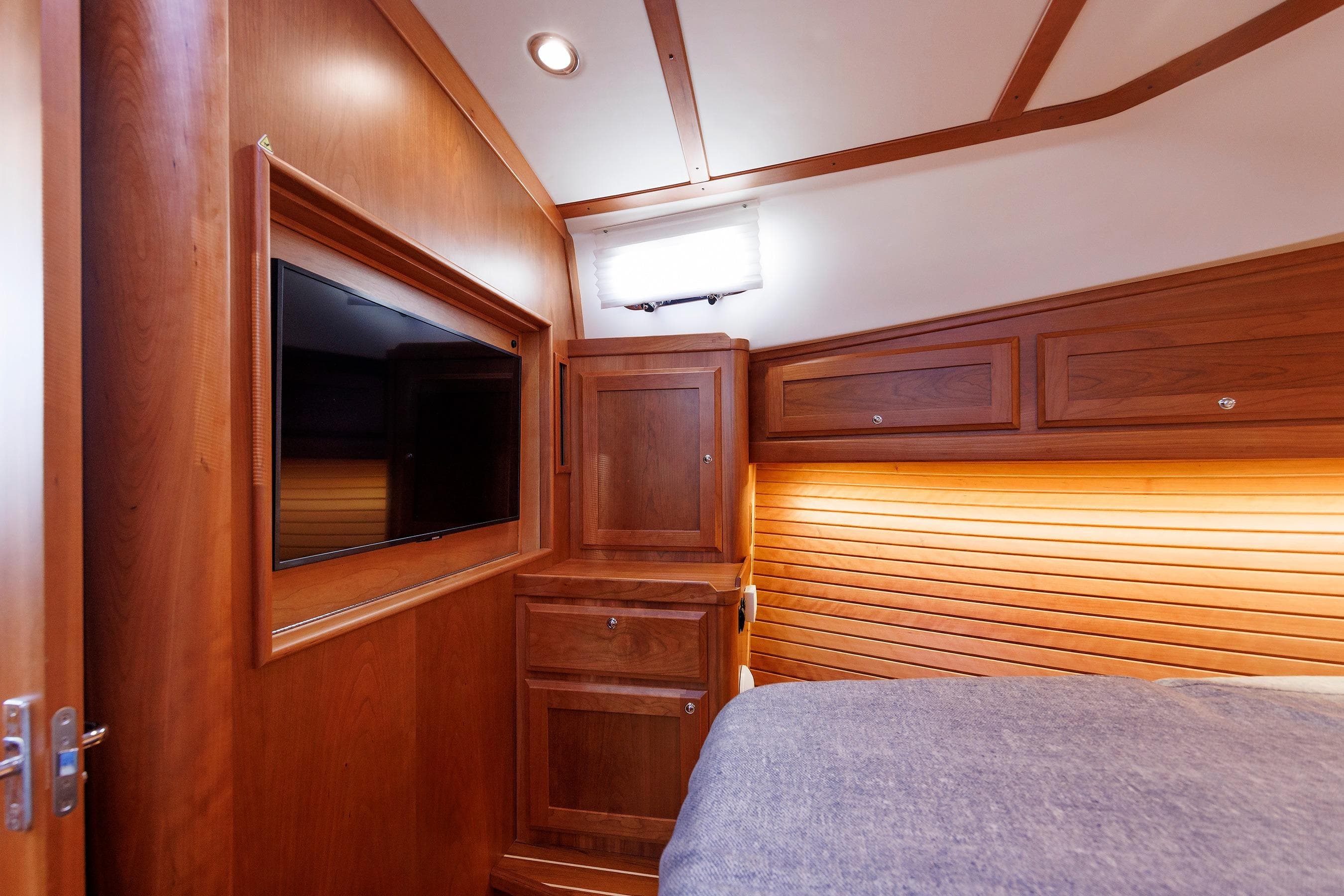Interior of 2022 Sabre 38 SE yacht with wood paneling and mounted TV.