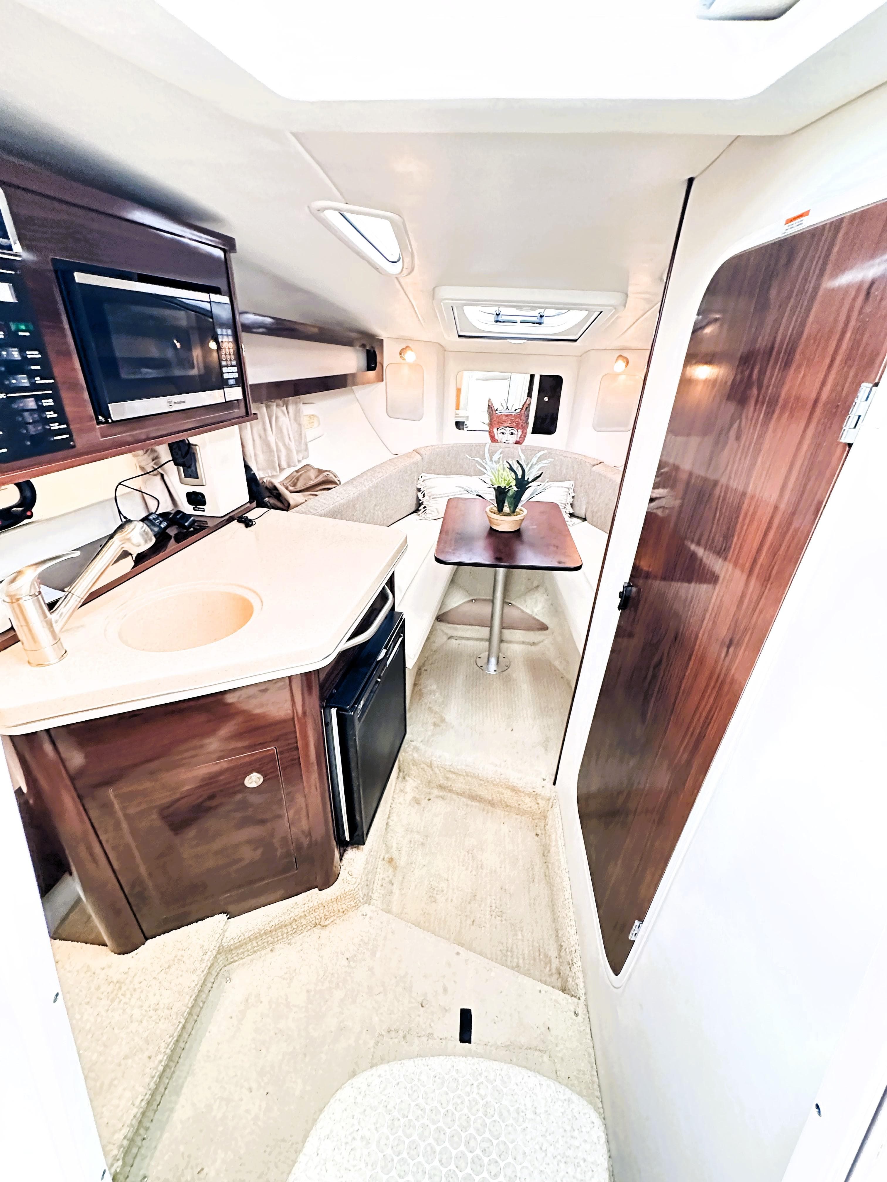 Interior of 2015 Sea Ray 260 Sundancer, featuring kitchenette and seating area.