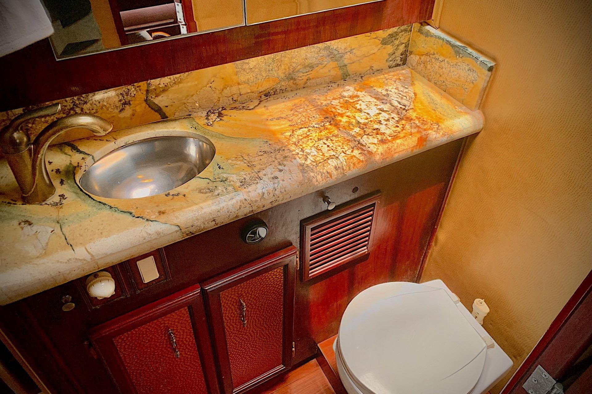 Luxurious bathroom in 1984 Egg Harbor 48' Flybridge yacht with marble countertop and modern fixtures.