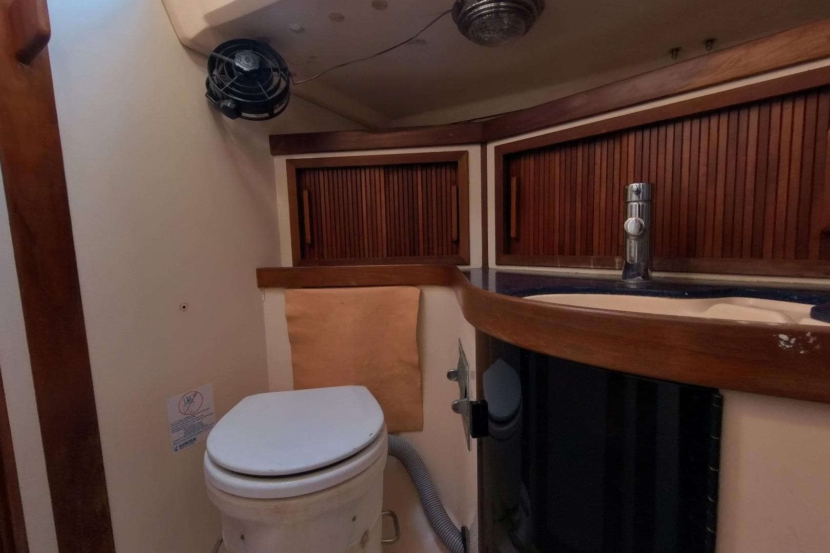 1999 Sabre 402 yacht bathroom with wooden cabinets and compact toilet.