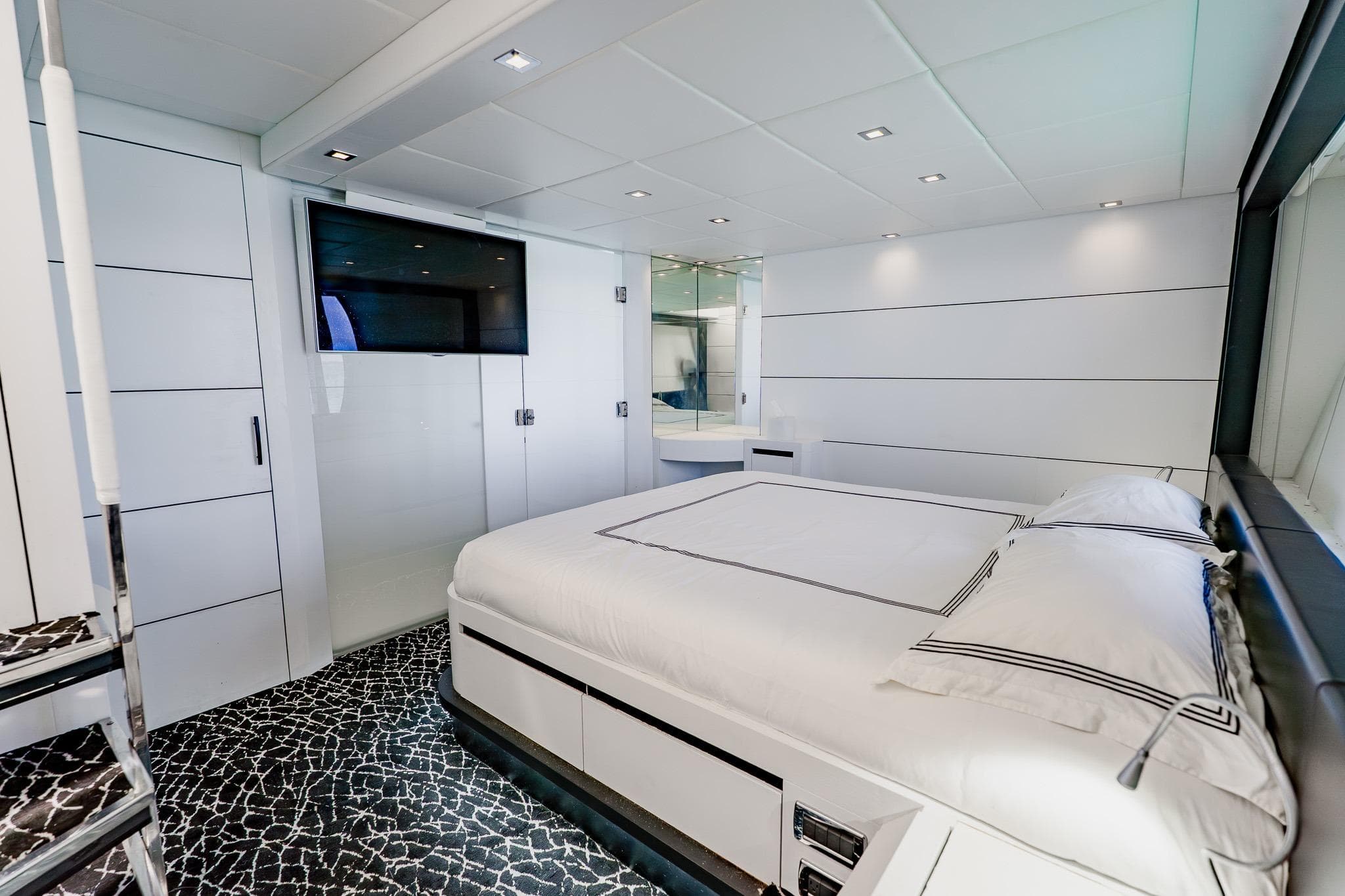 Luxurious bedroom interior on a 2010 Pershing 80 yacht, featuring modern design and elegant decor.