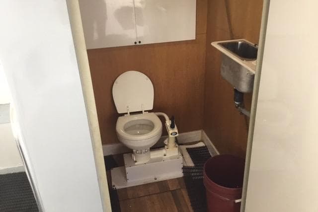 Restroom interior of 1979 Willard Marine 50 Utility Launch with toilet and sink.