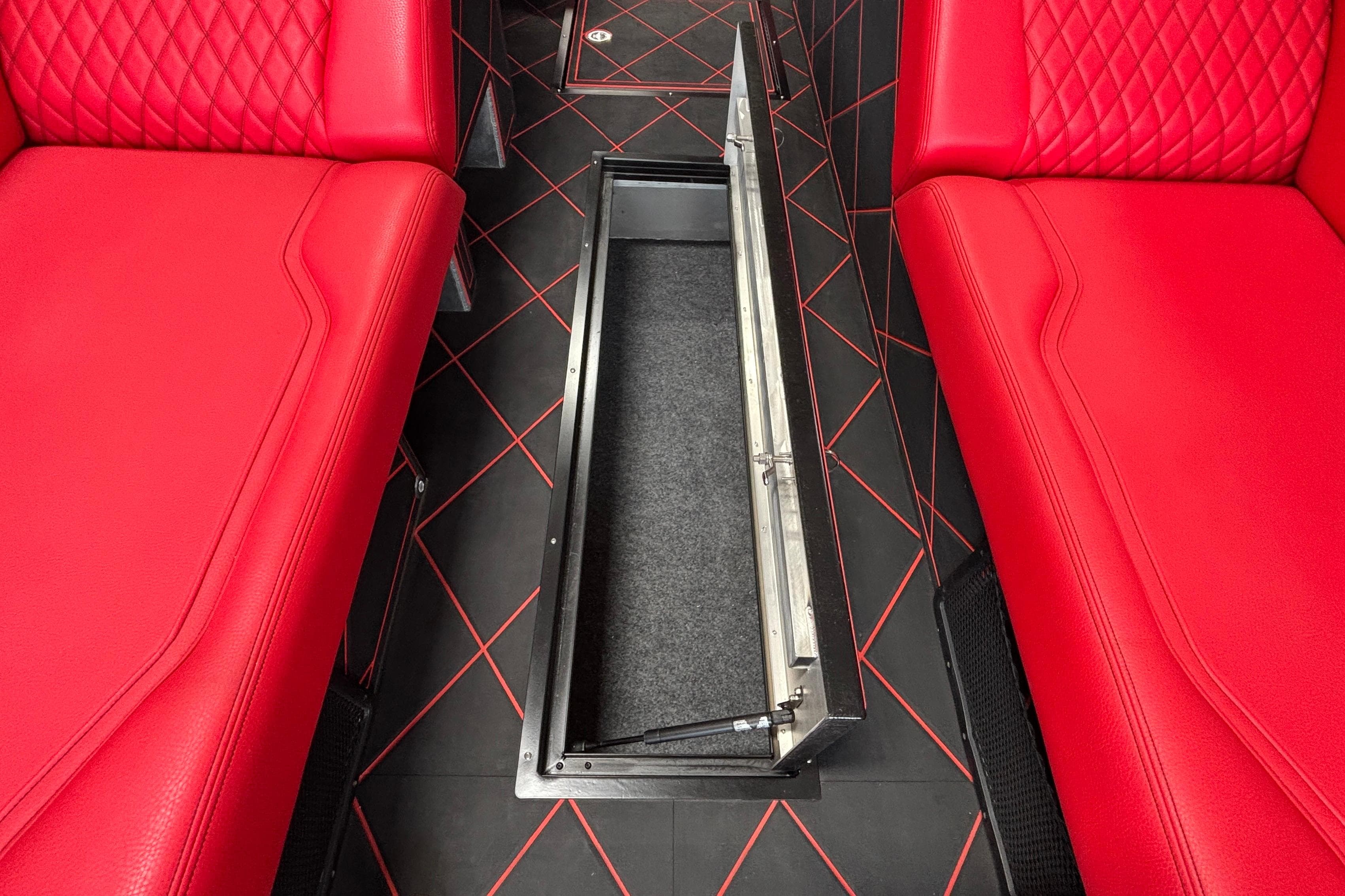 Red leather interior of 2026 Anthem Assault VF23 with open floor compartment.