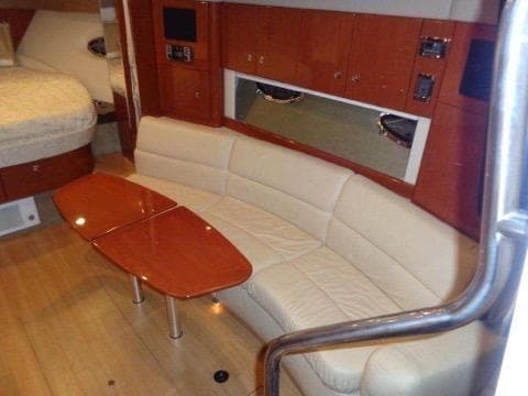 Interior of 2012 Formula 34 Cruiser with beige leather seating and wooden table.