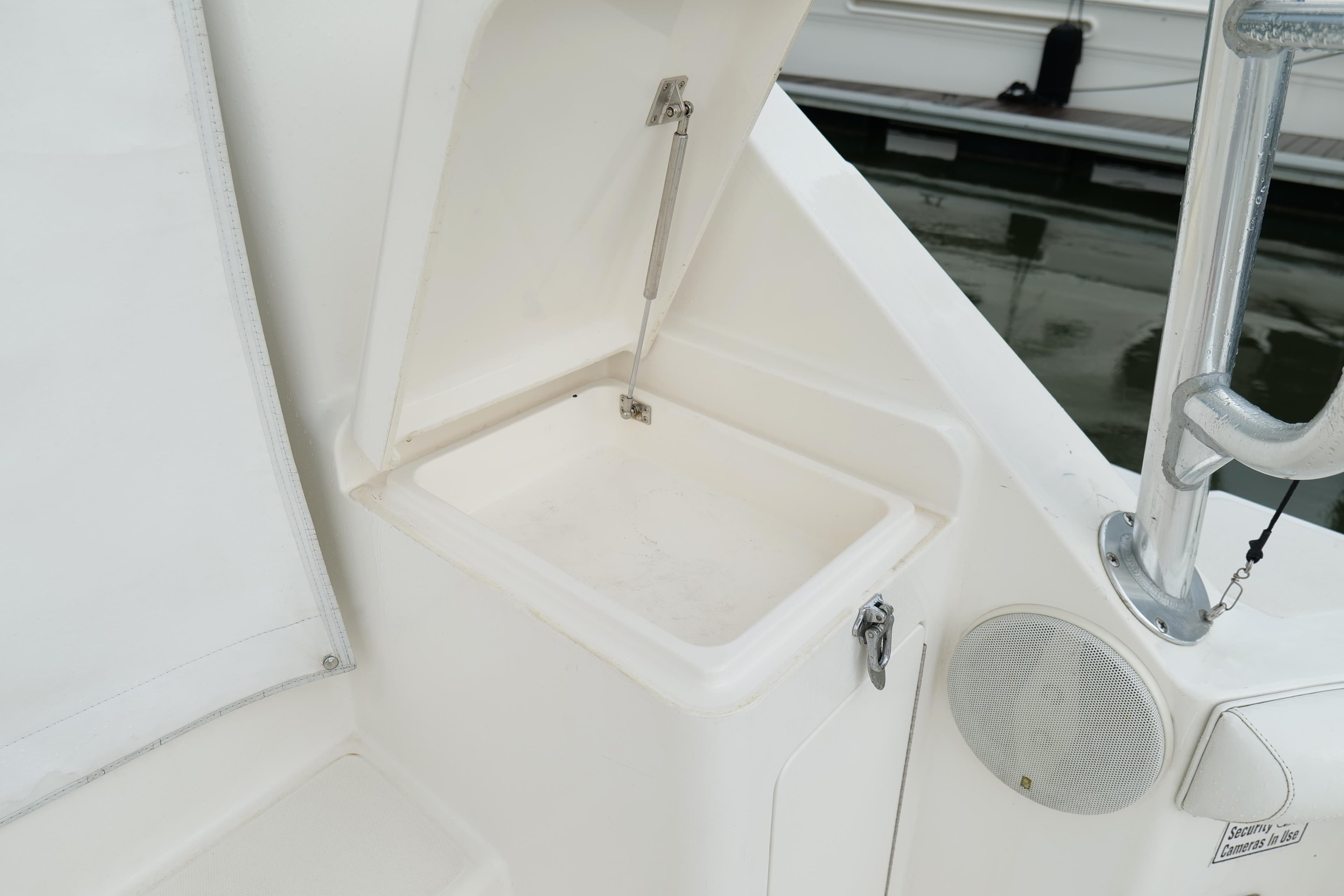 Storage compartment on a 1998 Cabo 45 Express boat, featuring a white interior and speaker.
