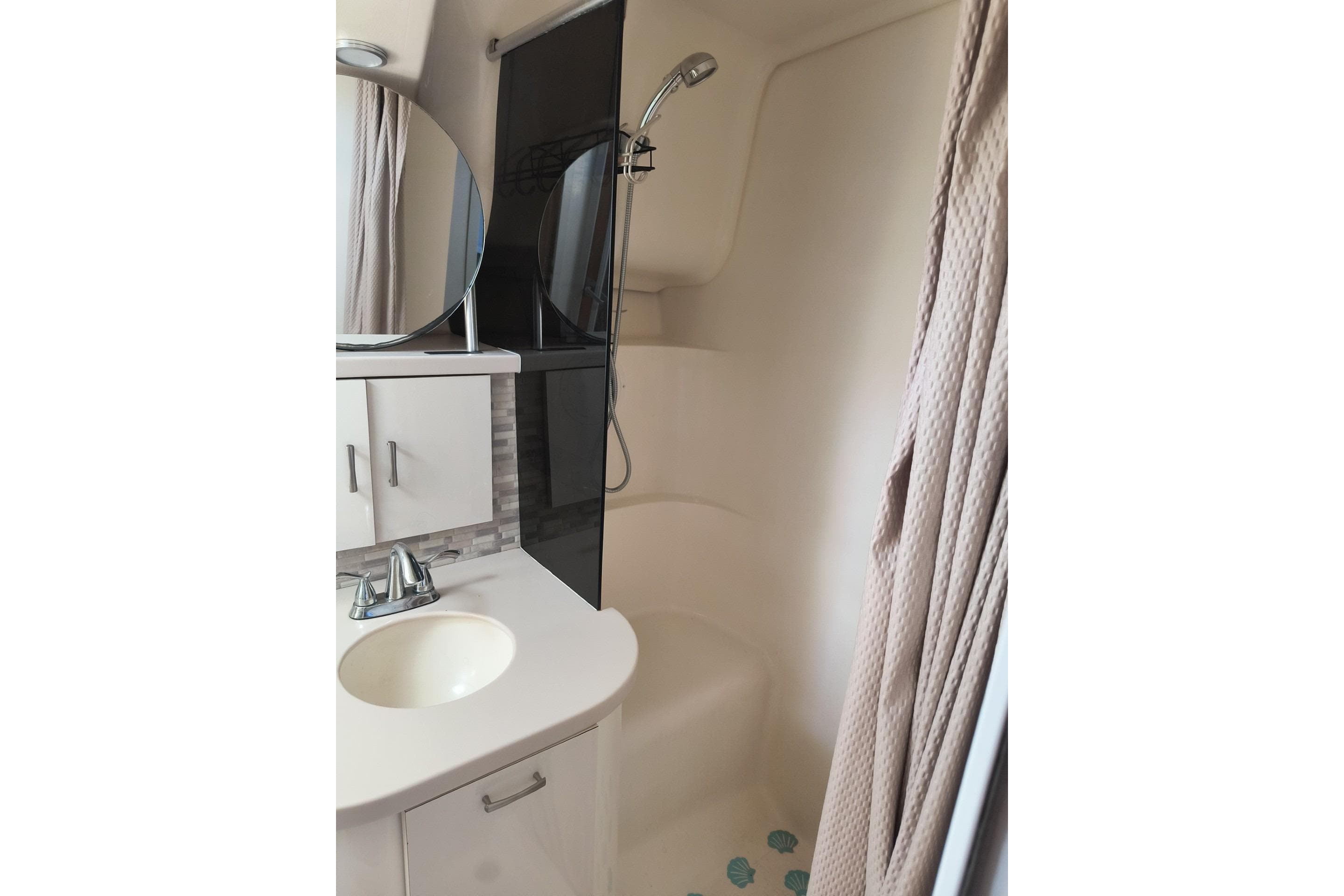 Bathroom interior of 1996 Mainship 40 Sedan Bridge with shower and vanity.