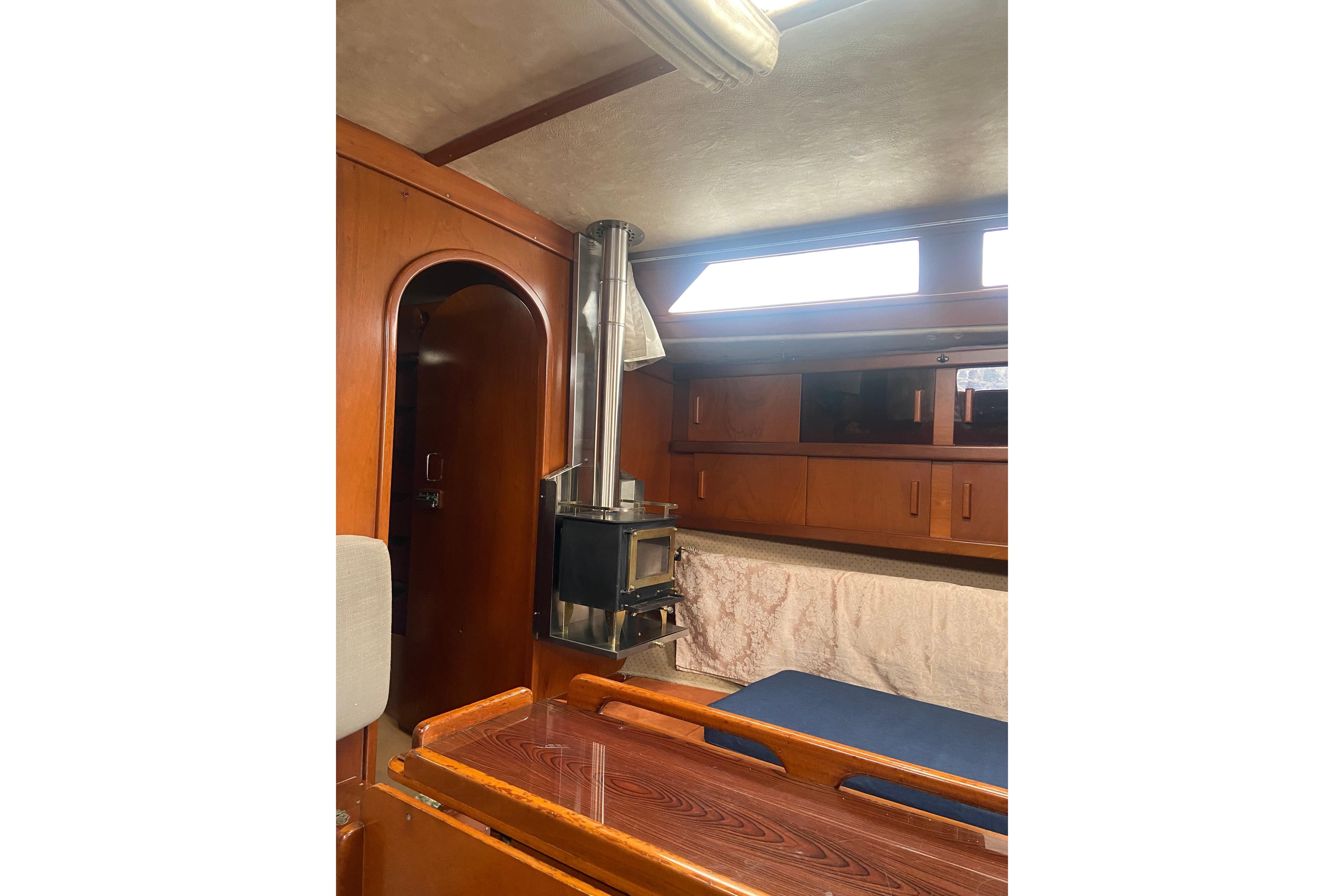 Interior of 1985 Amel Sharki sailboat with wood finish and stove.