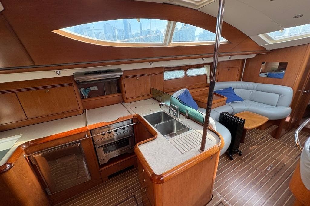 Luxurious interior of 2005 Jeanneau Sun Odyssey 54 DS yacht with modern kitchen and seating area.